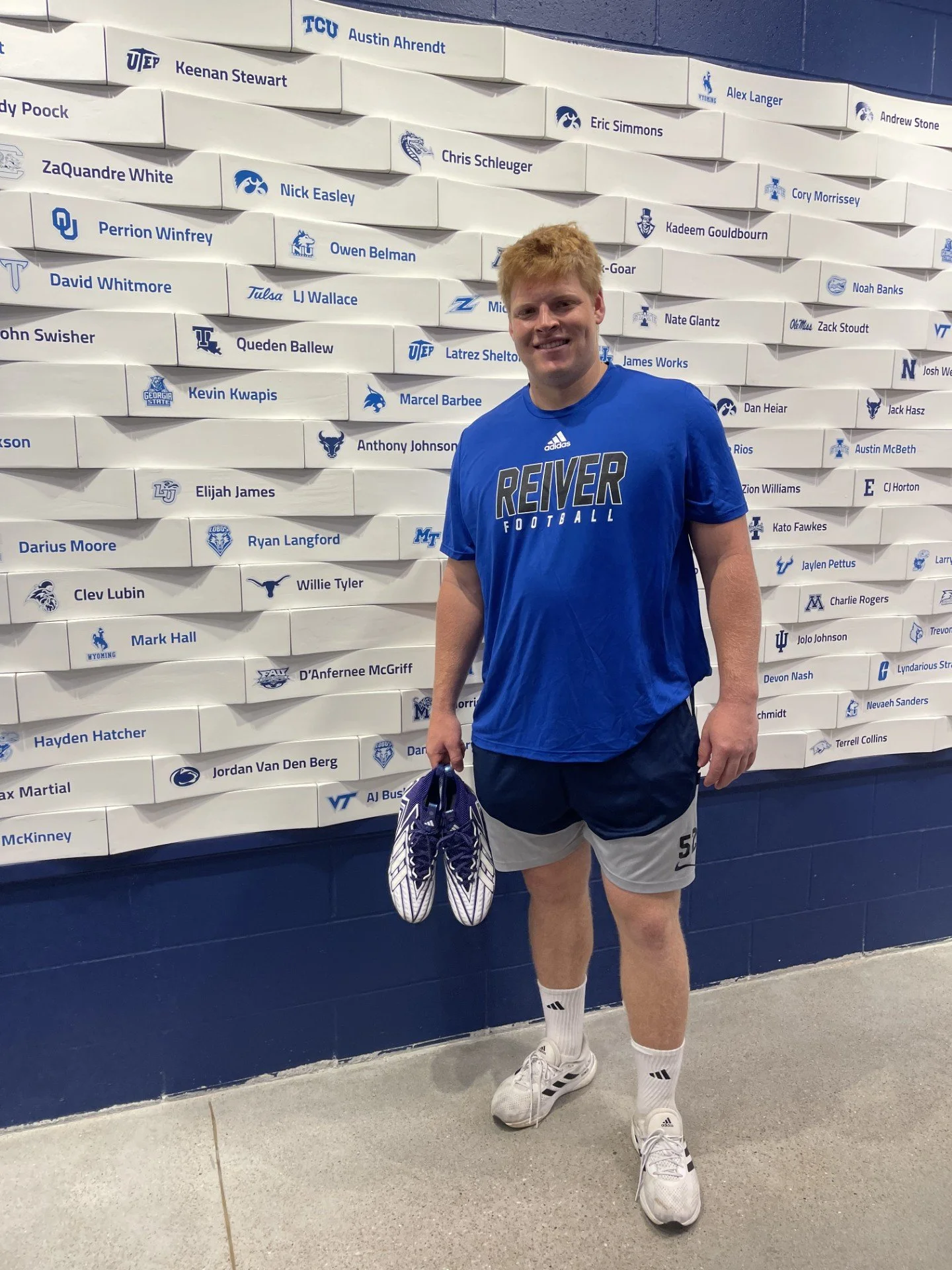 #DLineU Jordan Van Den Berg standing in front of Iowa Western Football wall Reivers at the Next Level