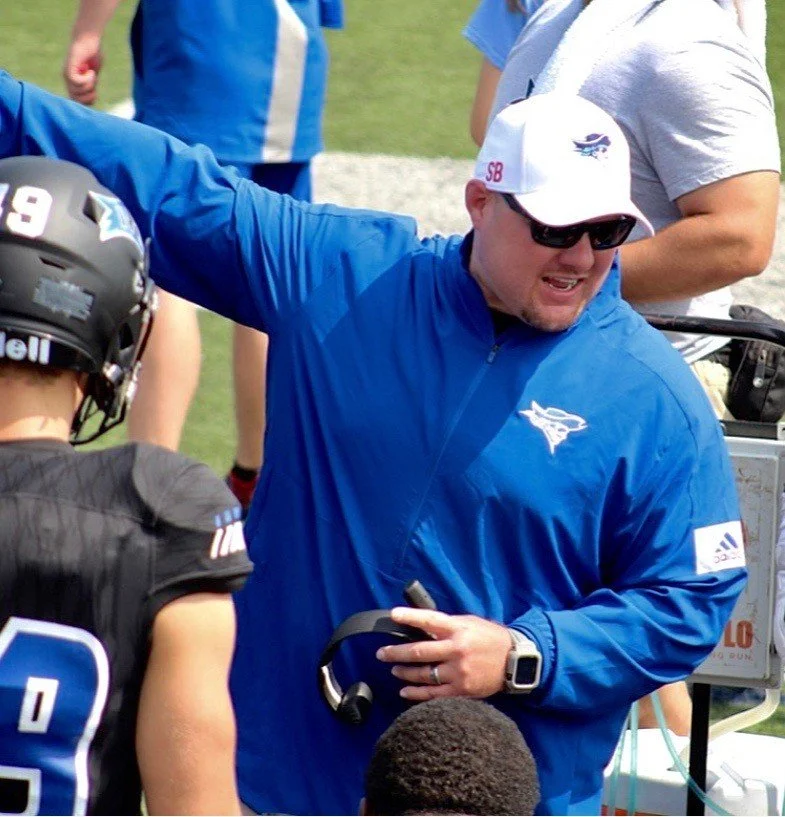 #DLineU Coach Aaron Terry talking to players making adjustments during a football game at Iowa Western