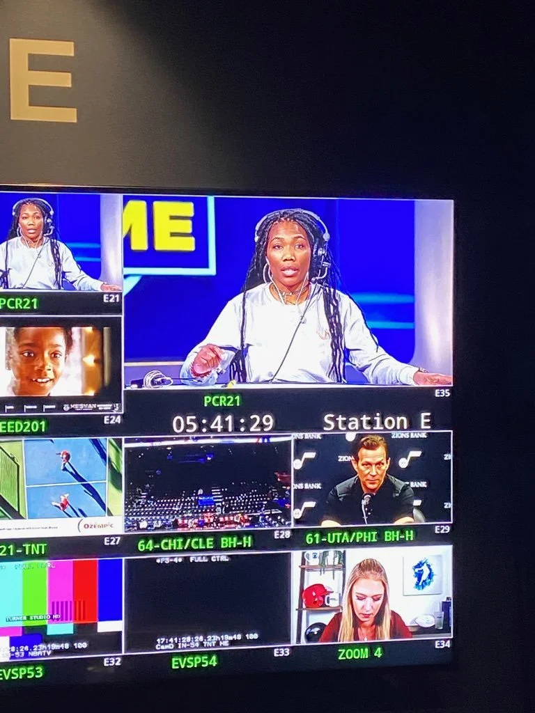 Television screen showing a sports broadcasting studio with multiple commentators and camera feeds.