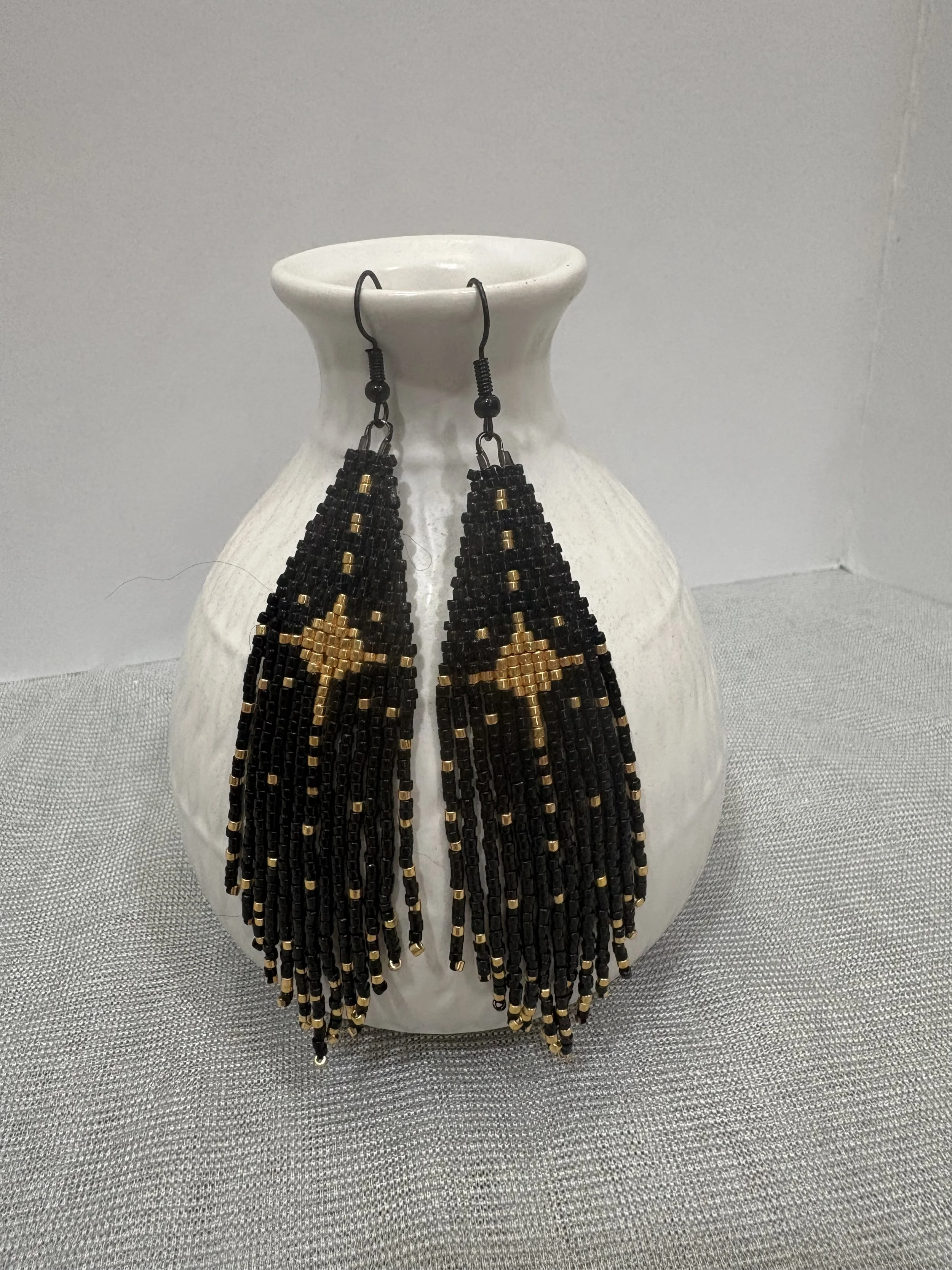Celestial handmade black and gold beaded fringe earrings with gold starburst design