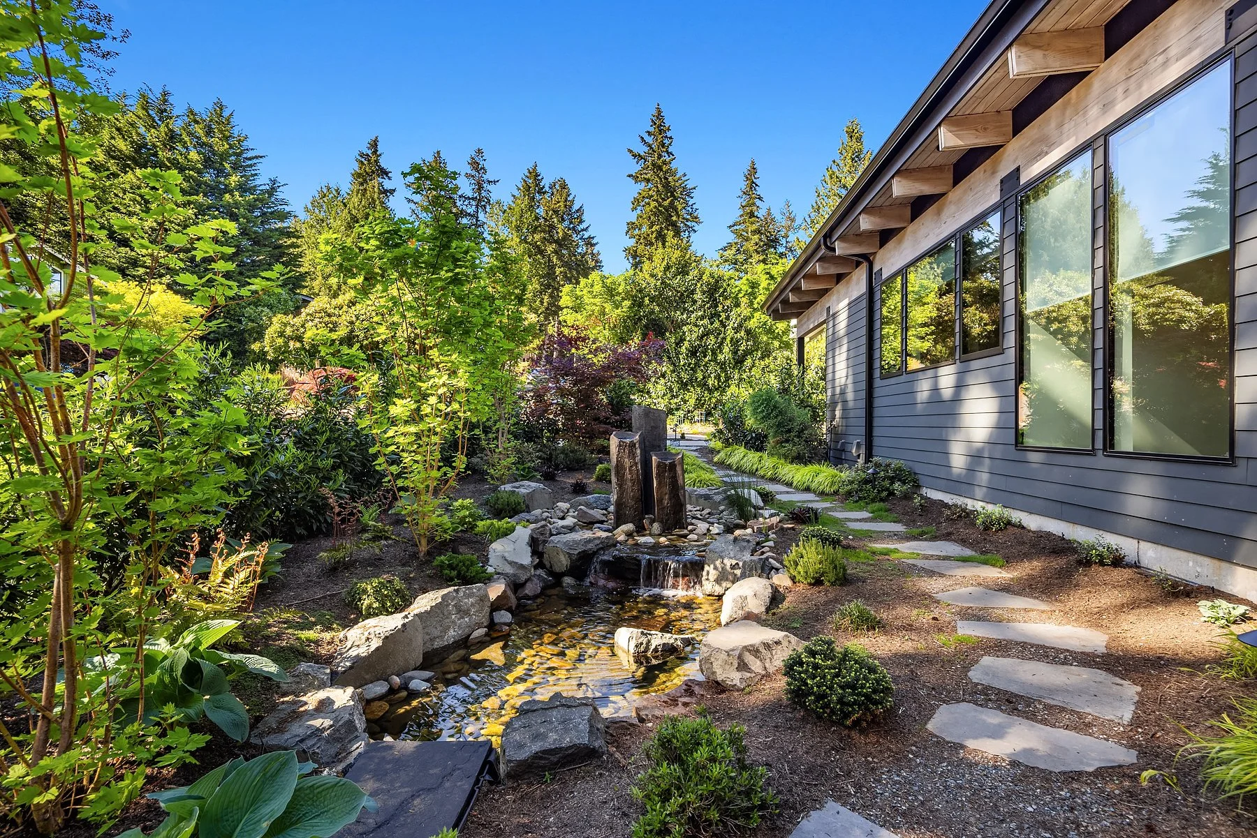 water feature with fish, surrounded by low maintenance, lush landscaping 