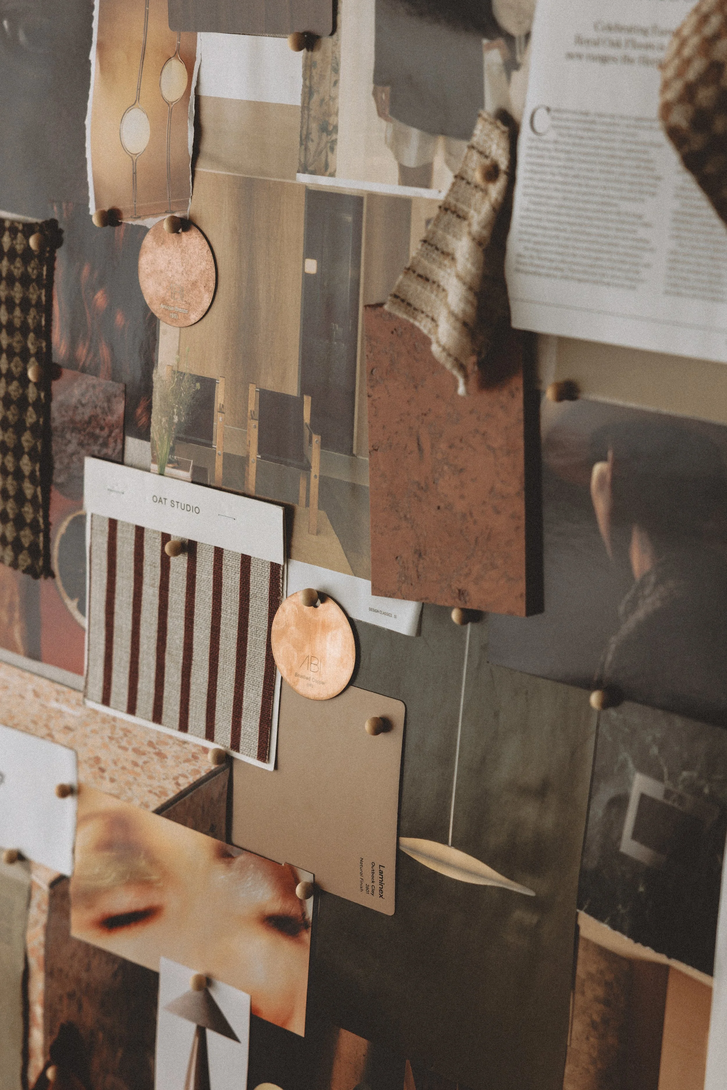Various design color samples, rugs, and brochures displayed on a dark table in a design studio.