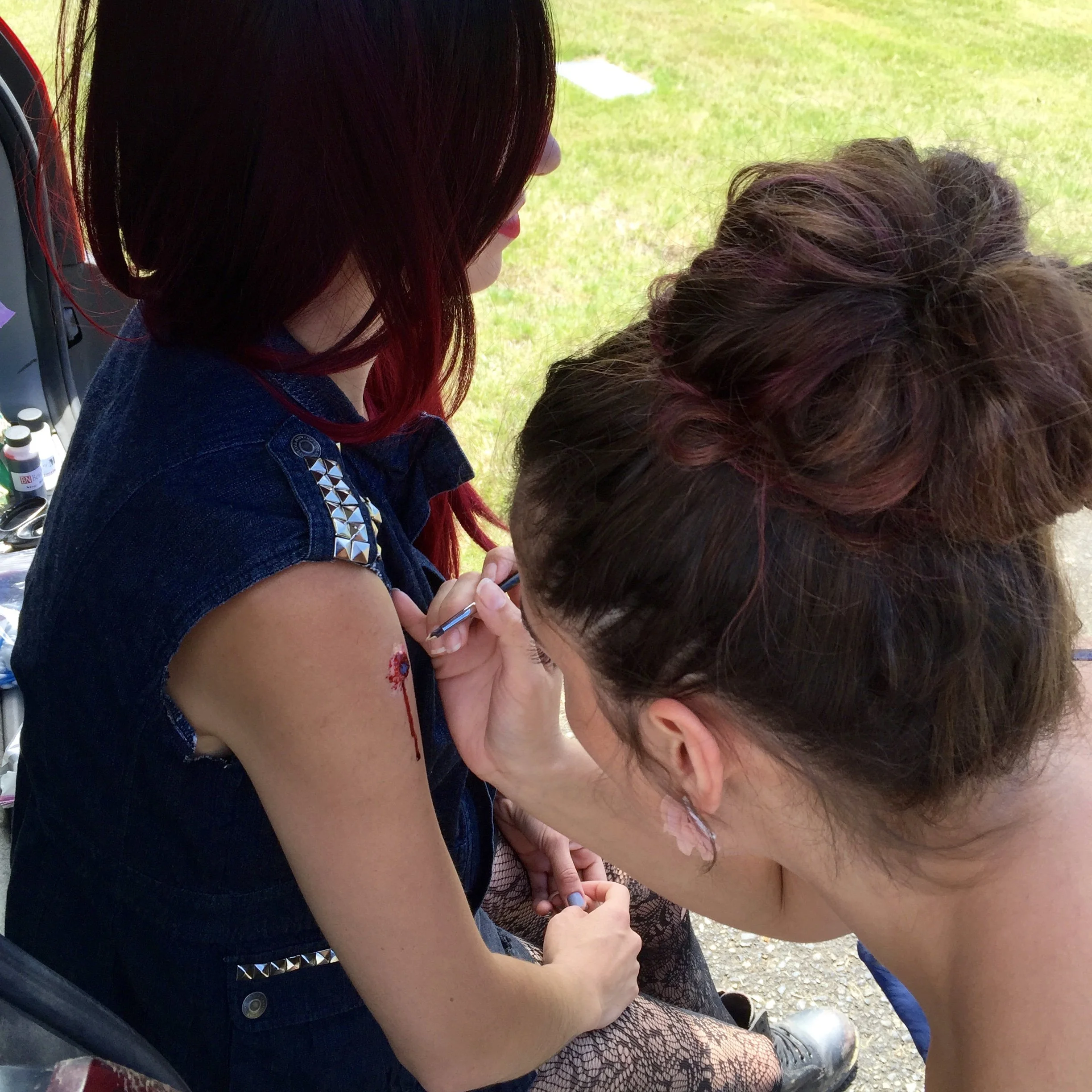 Makeup and FX artist painting bullet wound
