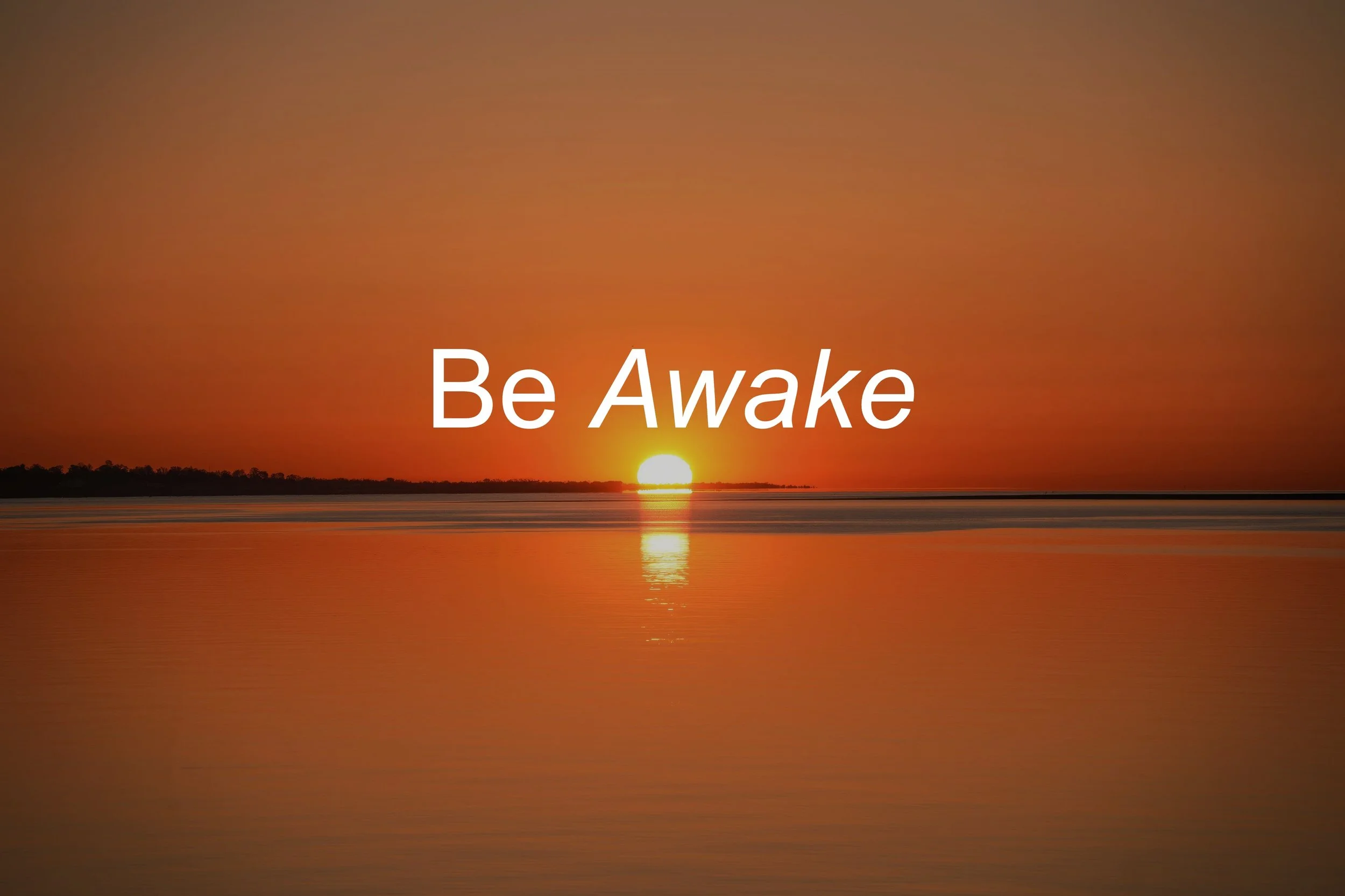 Sunset over a body of water with the text 'Be Awake' in the foreground.
