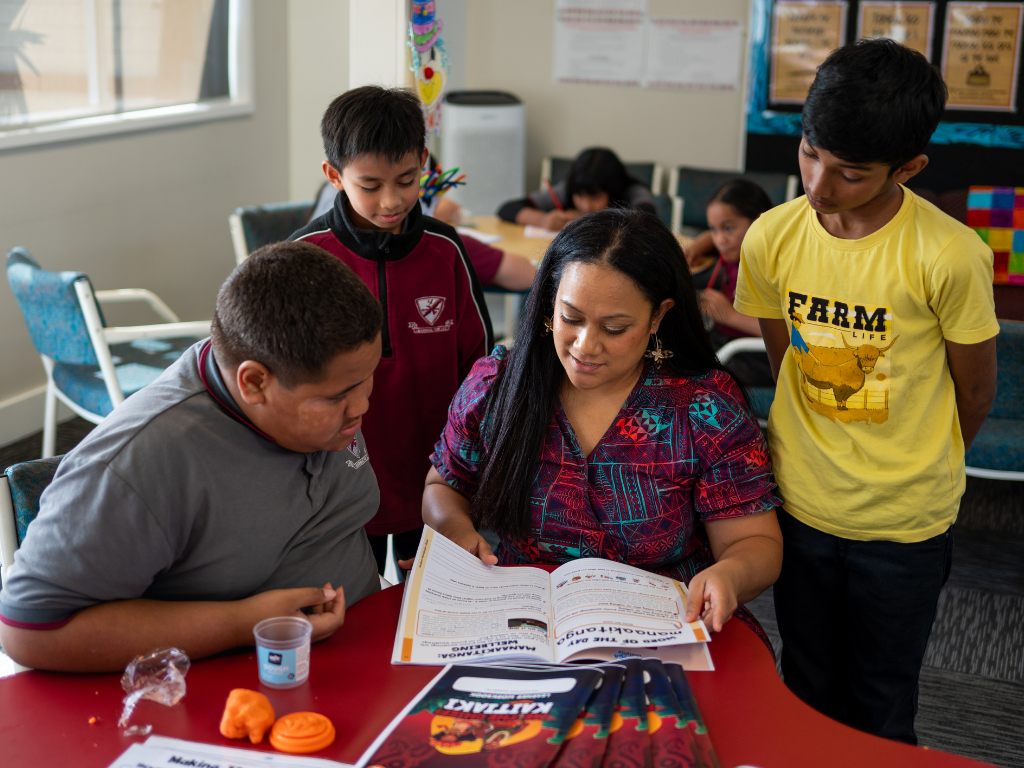 Teacher supporting students through collaborative learning using Lālanga classroom resources and engaging educational activities.