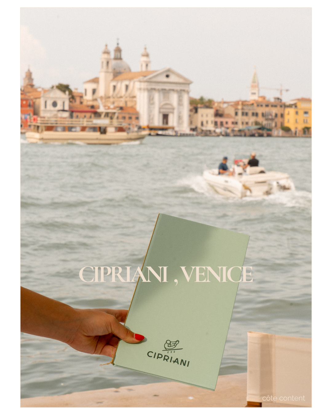 Person holding a Cipriani, Venice menu with the Venetian cityscape and water in the background, including boats and historic buildings.