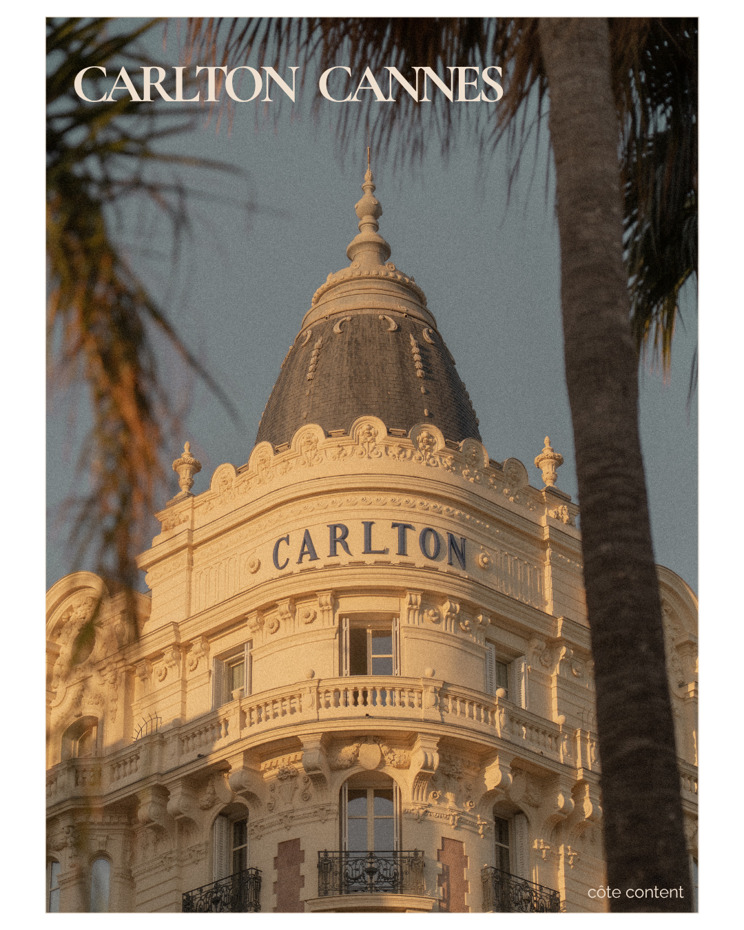 Close-up of the Carlton Cannes hotel building with its ornate architecture and rounded turret, framed by palm trees, during the golden hour.