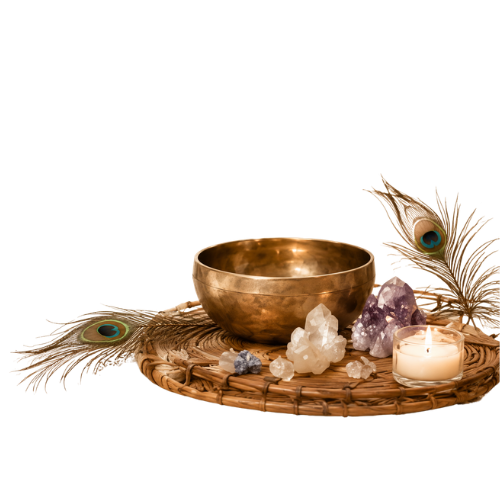A brass singing bowl, peacock feathers, crystals, and a lit candle on a woven tray.