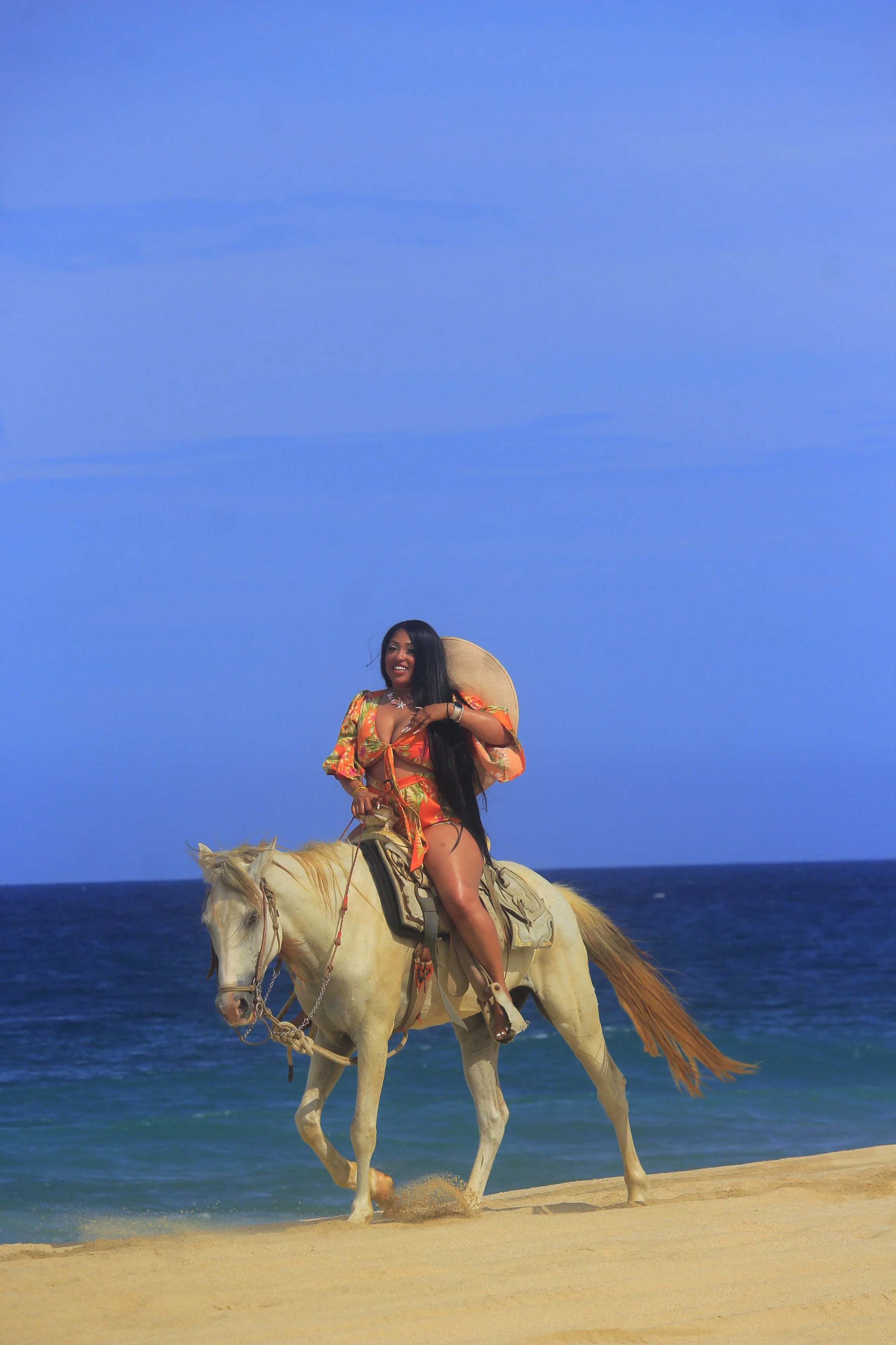 Jessica Holland riding a white horse along the Pacific coast near Cabo San Lucas, Mexico.