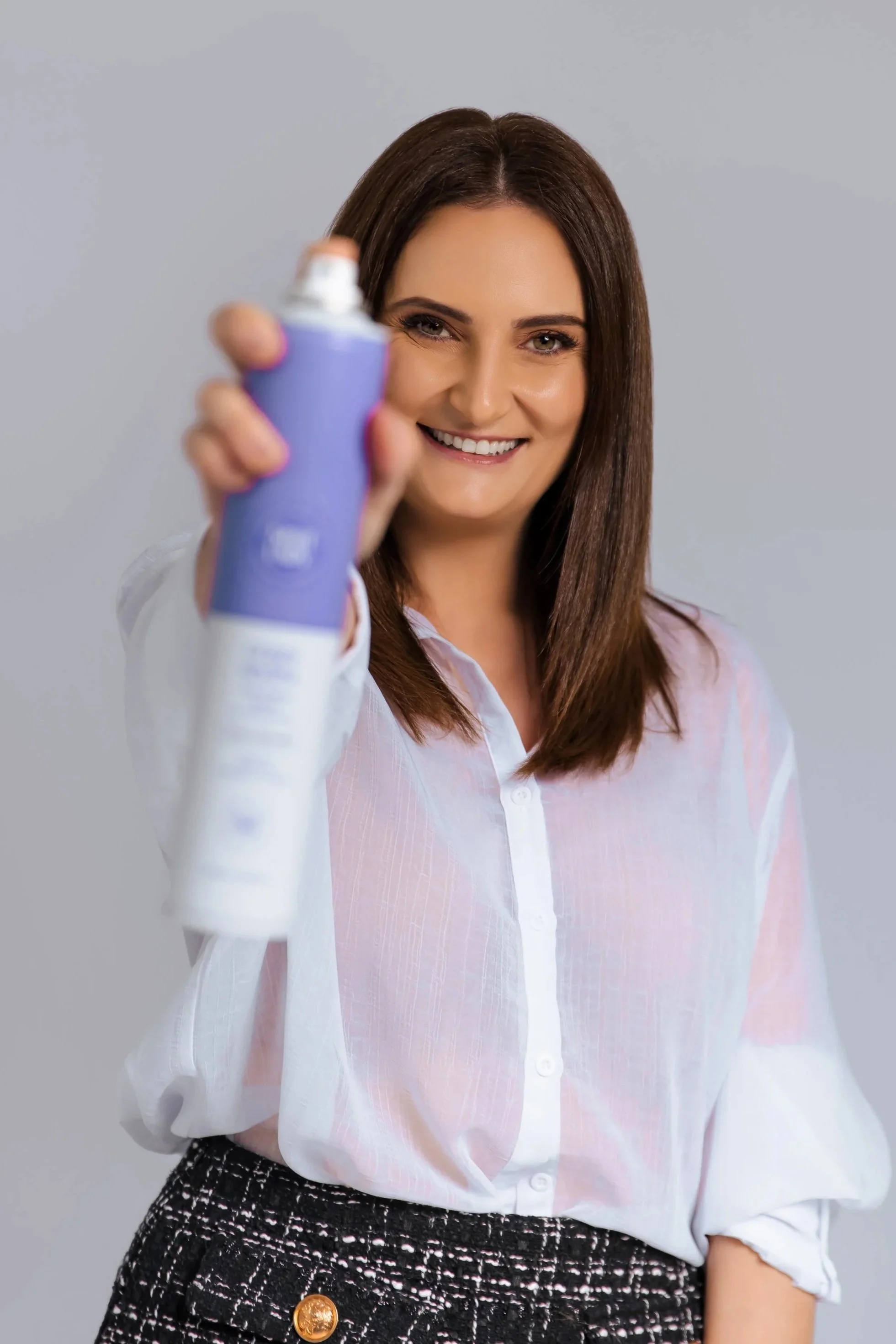 Yasmen holding a professional hair styling product at Jazz Up Your Hair in Eagle Vale, NSW
