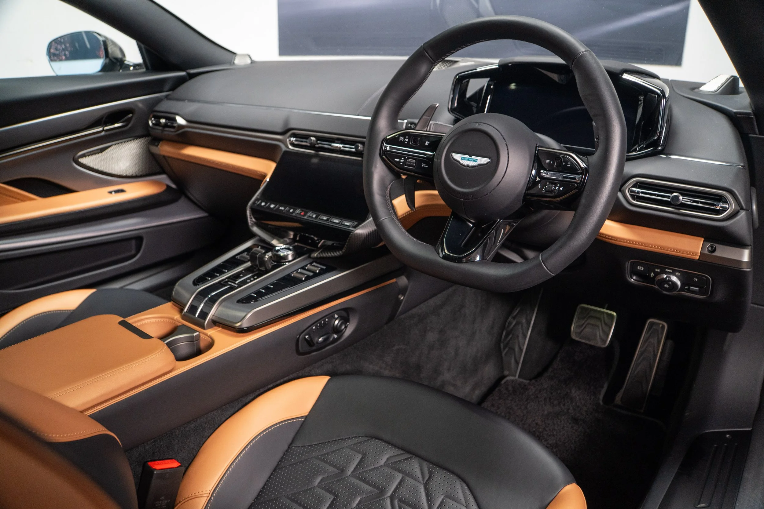 Interior of a luxury car showing the dashboard, steering wheel, and center console with leather seats and modern controls.