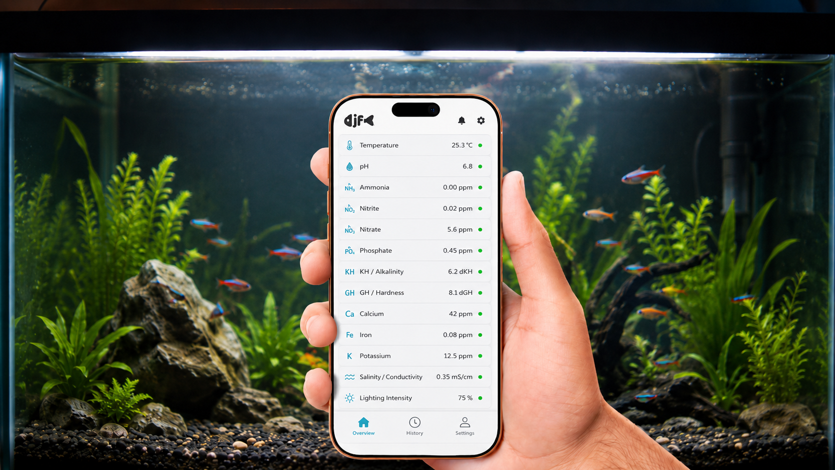 Hand holding a smartphone with an aquarium monitoring app open, showing water parameters such as temperature, pH, ammonia, nitrite, nitrate, phosphate, and other water quality metrics, with a planted fish tank in the background.