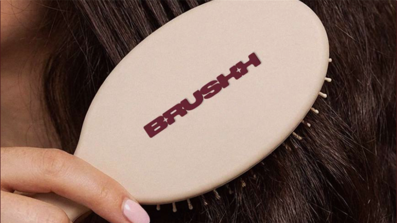Close-up of a person combing their dark brown hair with a white hairbrush labeled 'BRAUSTH' in red letters.
