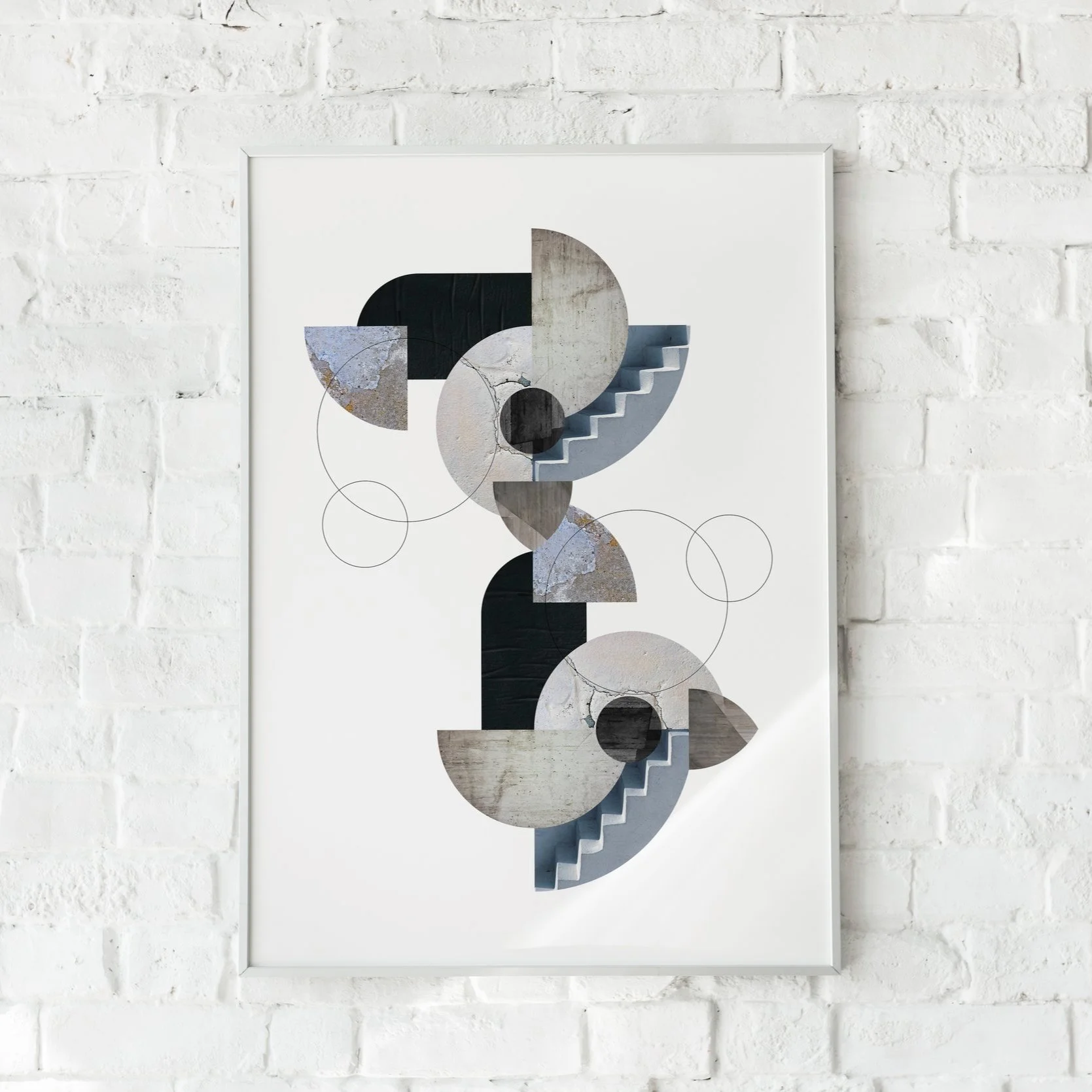Abstract geometric artwork with circles, semicircles, and stairs in neutral and muted tones, mounted on a white brick wall.