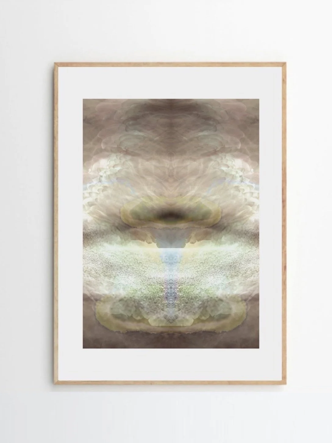 Abstract symmetrical artwork with muted tones of beige, brown, and pale blue, framed and hanging on a white wall.