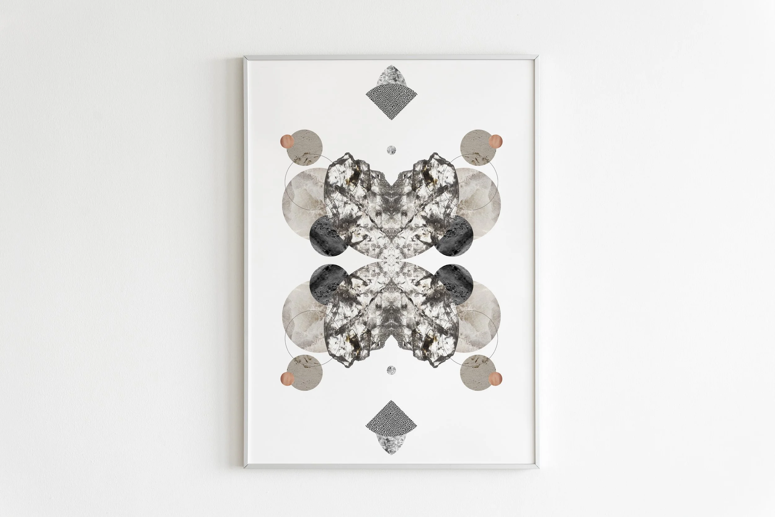 Abstract symmetrical art with black, gray, beige, and coral shapes on white background, framed on white wall.
