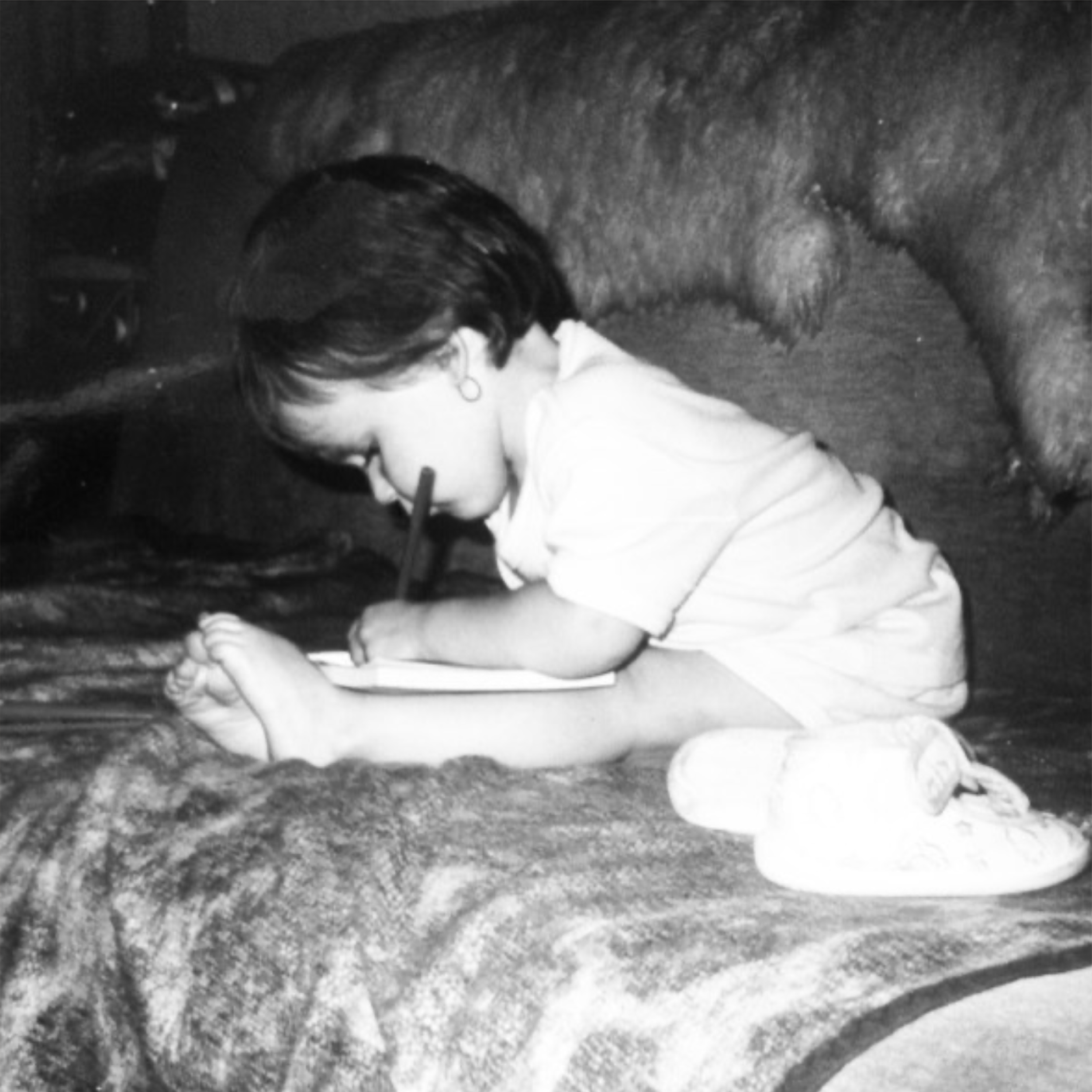 An old photo of Eszter Takács, founder of Eszter.Studio, drawing as a child, showing her all-time passion for creating.