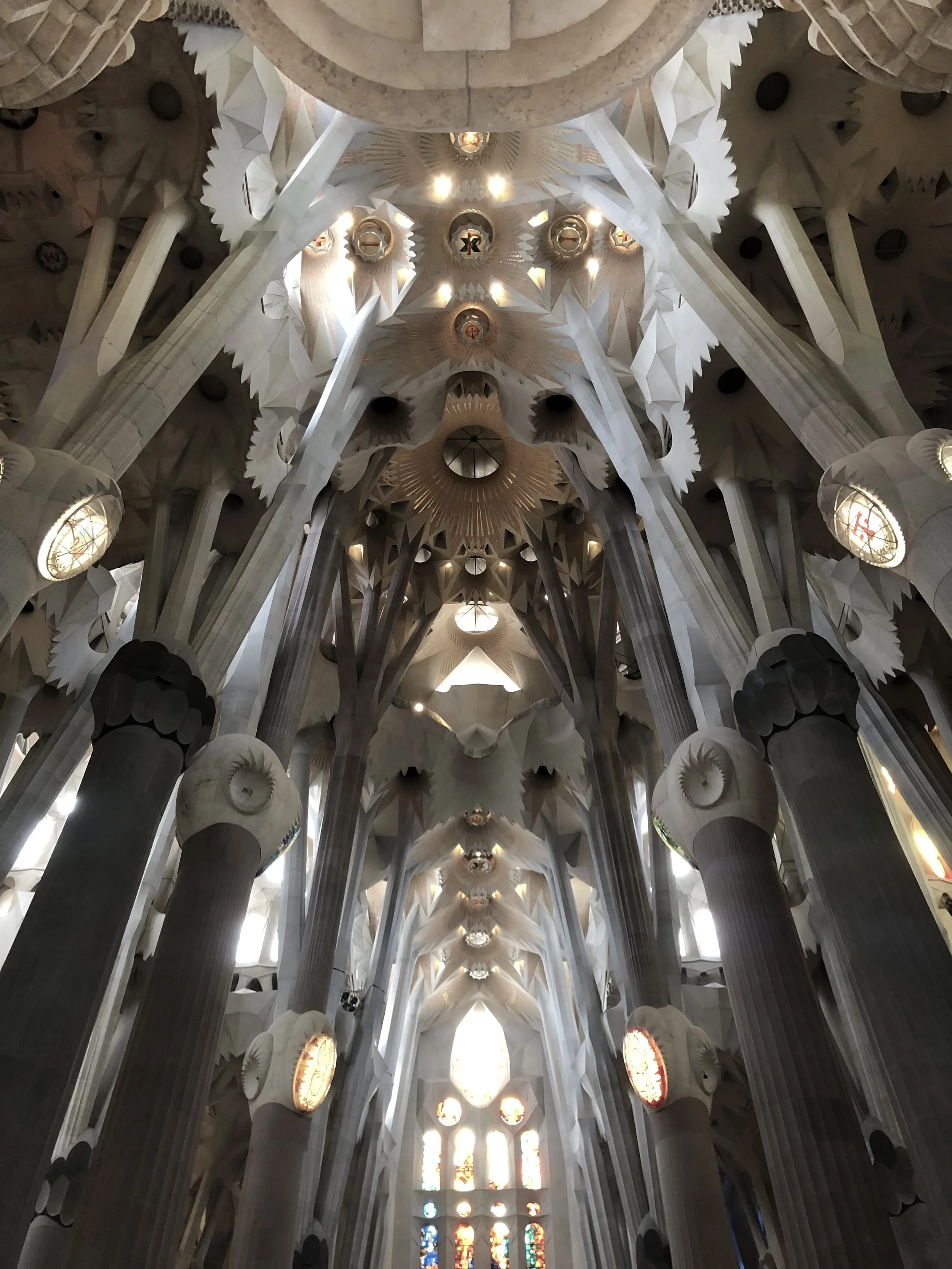 Interior view of the Sagrada Familia with tall columns and intricate ceiling details.