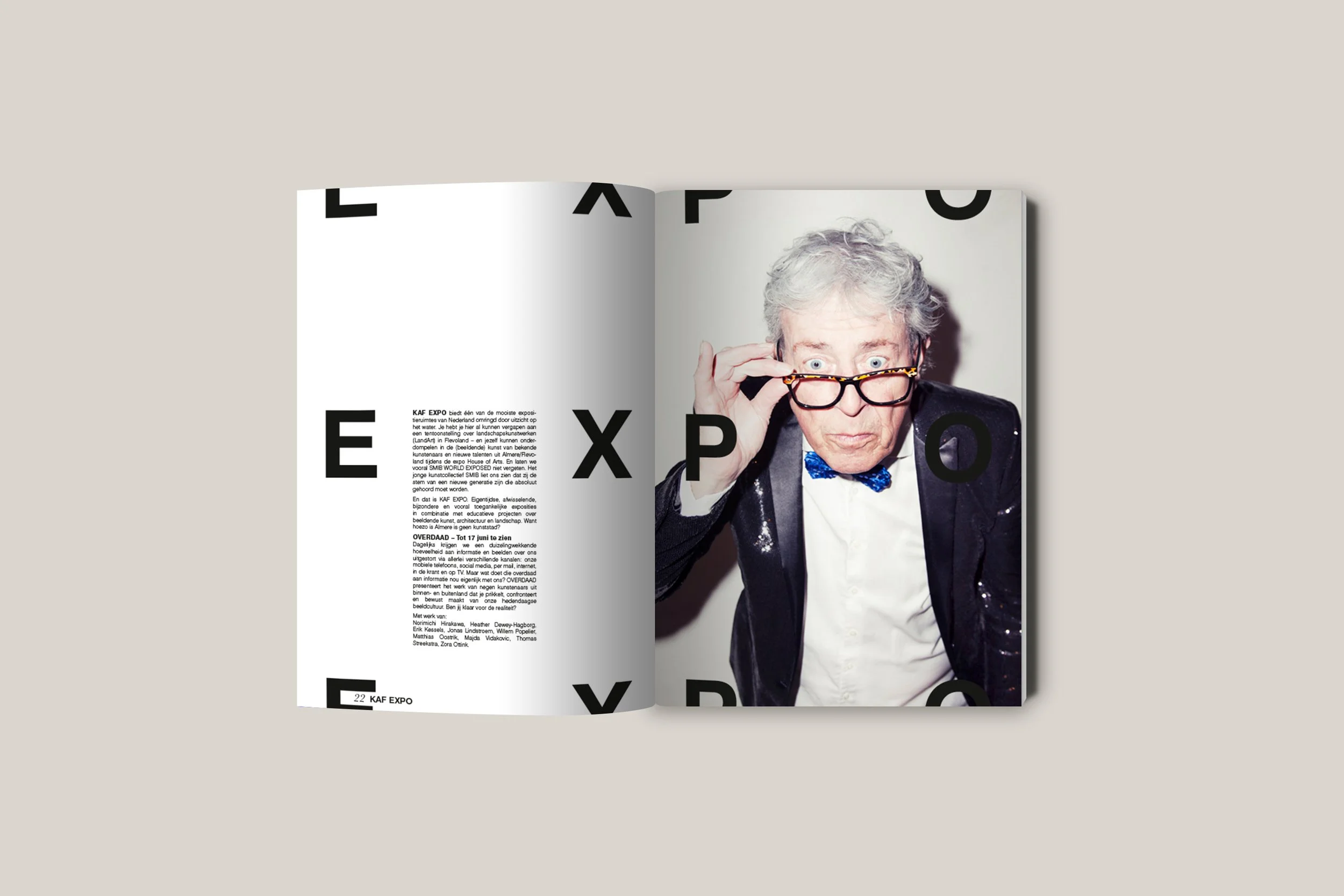 Open magazine with a black and white photo of an elderly man with gray hair, wearing glasses, a blazer with sequins, a white shirt, and a blue bow tie, adjusting his glasses, with large black letters spelling 'EXPO' overlaying the pages.