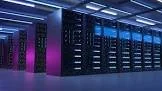 A row of server racks in a data center with blue and purple lighting.