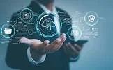 Person in business suit holding a smartphone with digital technology icons and data projections in the background.