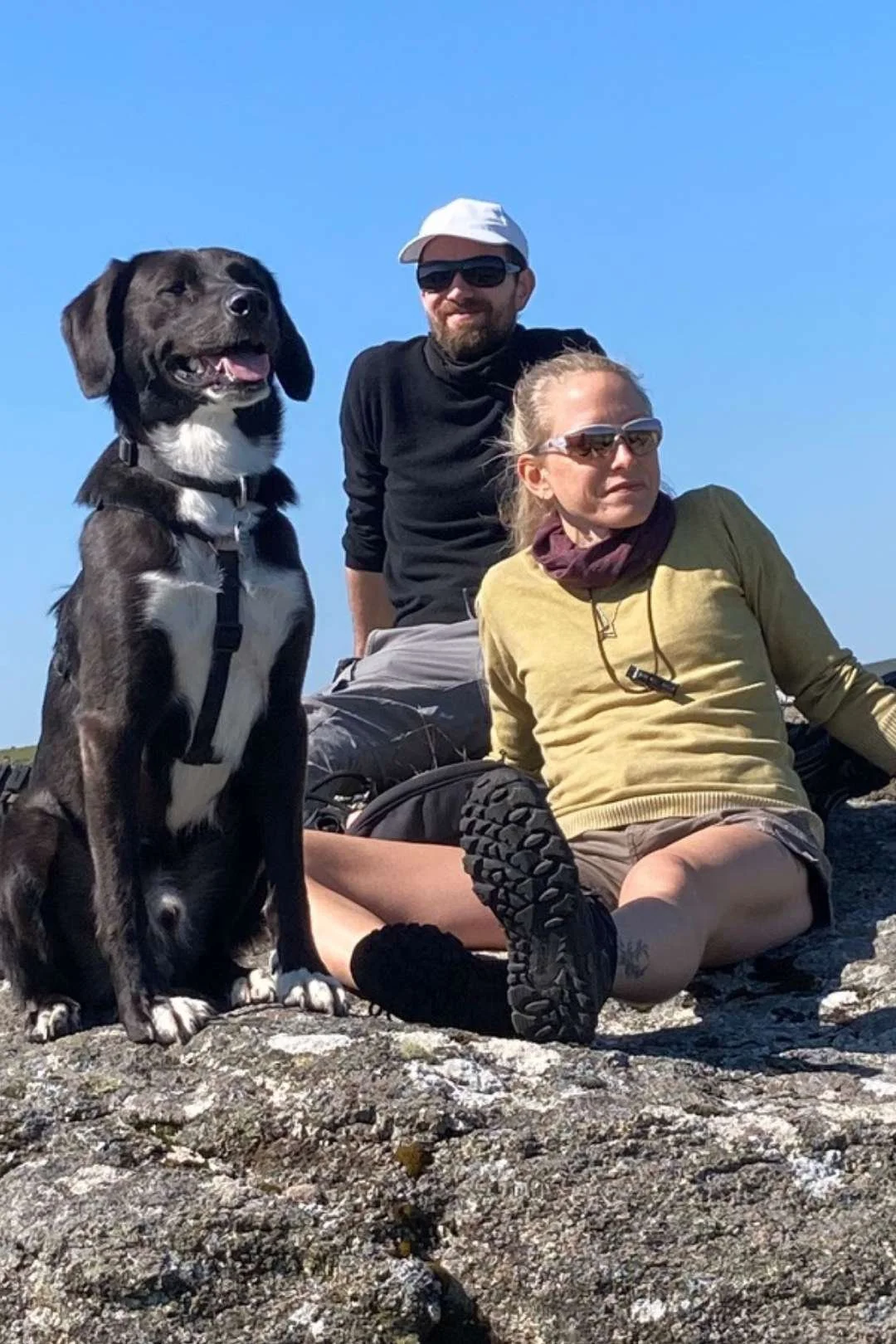 Julia, Tom and Buddy Austin sitting on a rock in during a dog walk in Dartmoor National Park