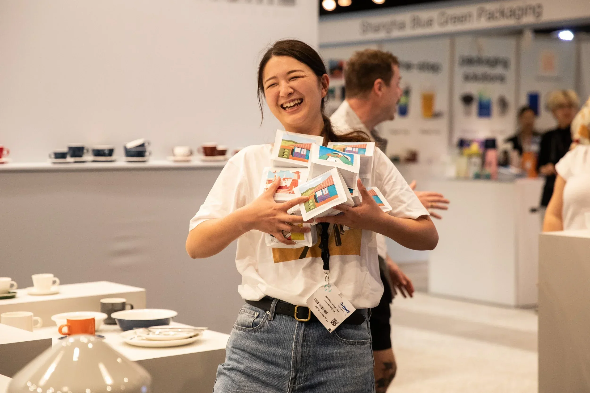 A person laughing while holding bags of coffee
