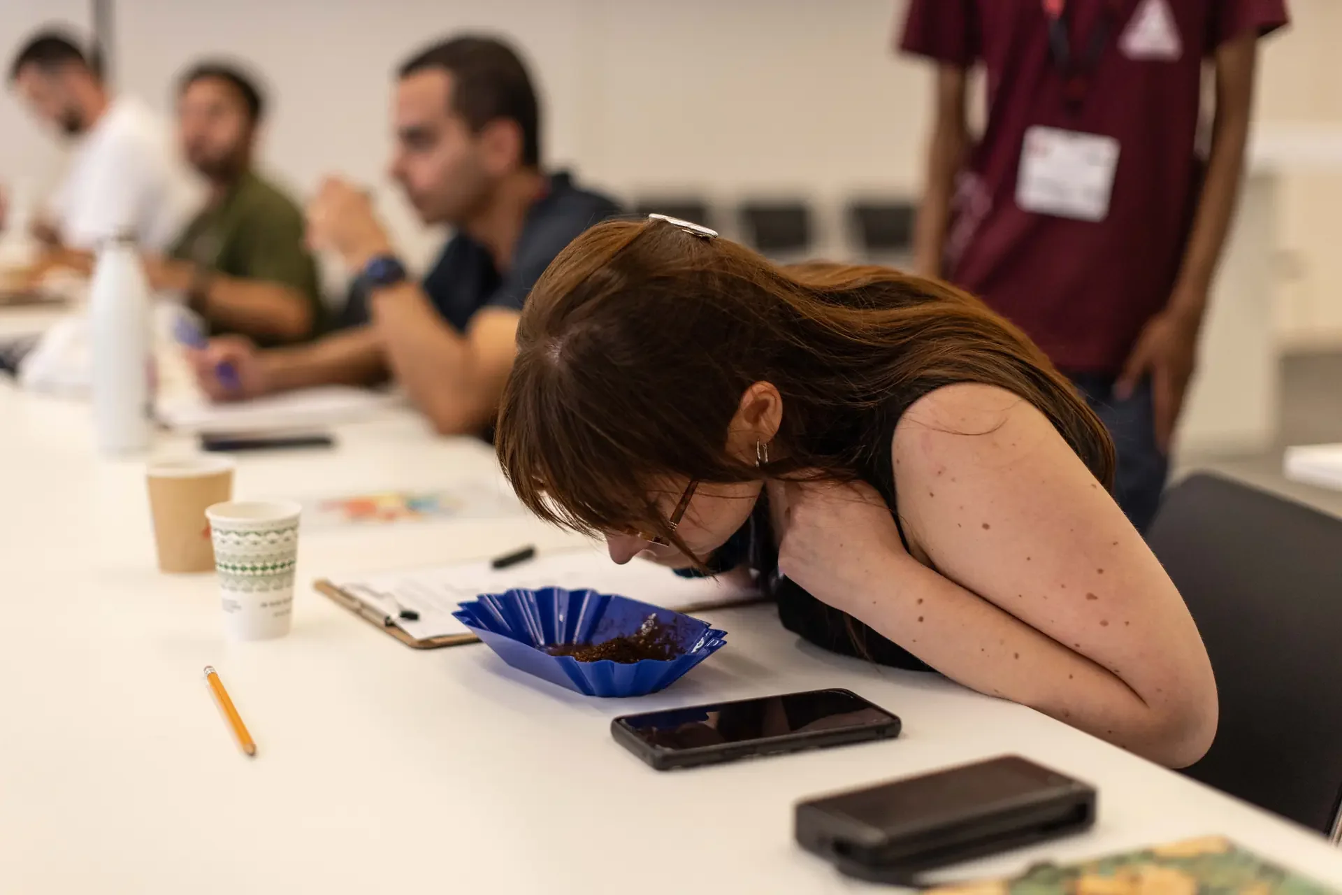Participant in World of Coffee lecture smells coffee grounds