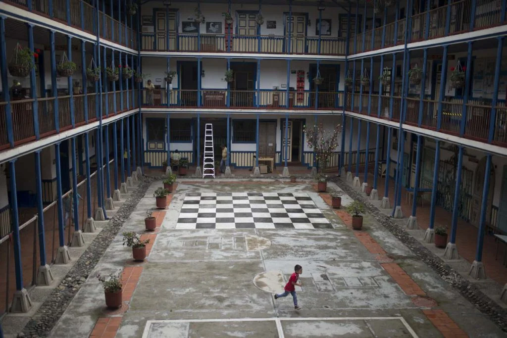 A child runs through the courtyard of the huge House of Marsella Culture to their band class. The building, which also houses a museum of Paisa culture, is a prime example of the local architectural typography, a fusion between Spanish cultural patt…