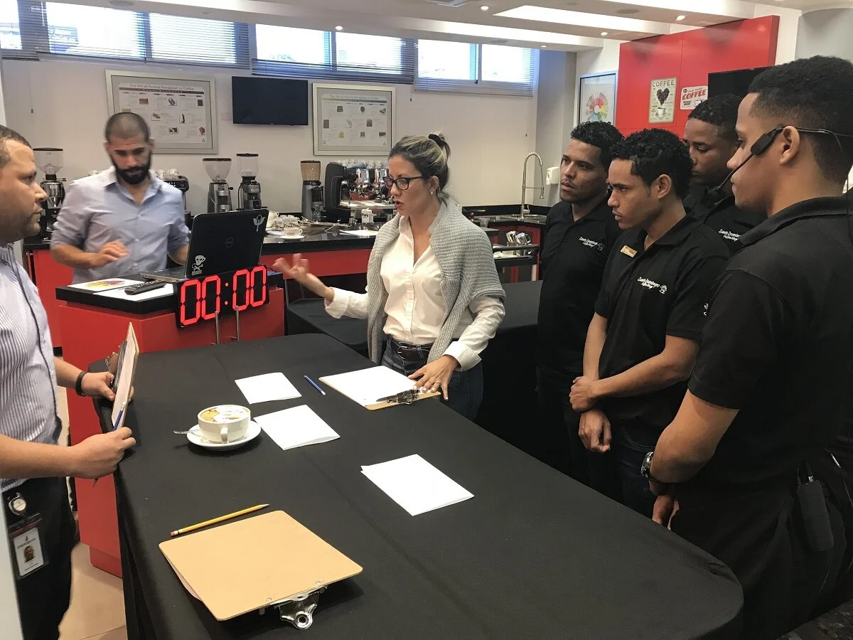 Erica Reyes (center) outlines the expectations of presentation in barista competitions to competitors Carlos Sánchez, Angel Menerson, Luis Perez, and Nelsouris Mejía. Image: Ben Helt.
