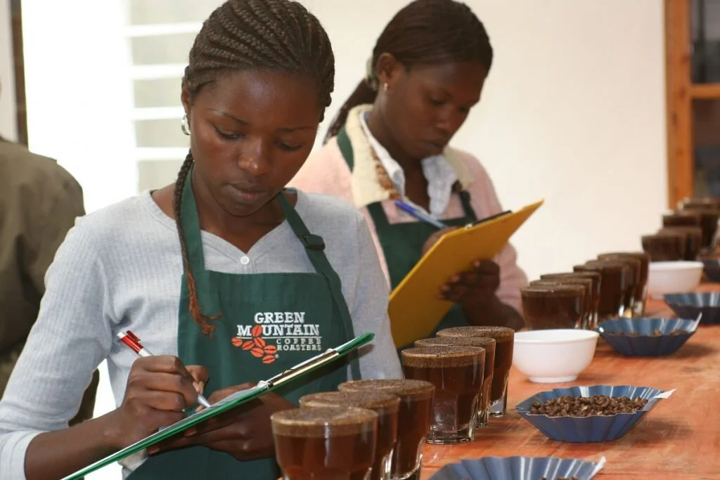 Laetitia Mukandahiro (izquierda) y Rachel Dushimiyimana (derecha) realizan la cata de cafés en un laboratorio de Huye, Rwanda. Tener un laboratorio para la cata de café dentro de la comunidad junto a las cooperativas resultó muy importante para aumentar la calidad y sensibilizar acerca de la calidad y el precio.