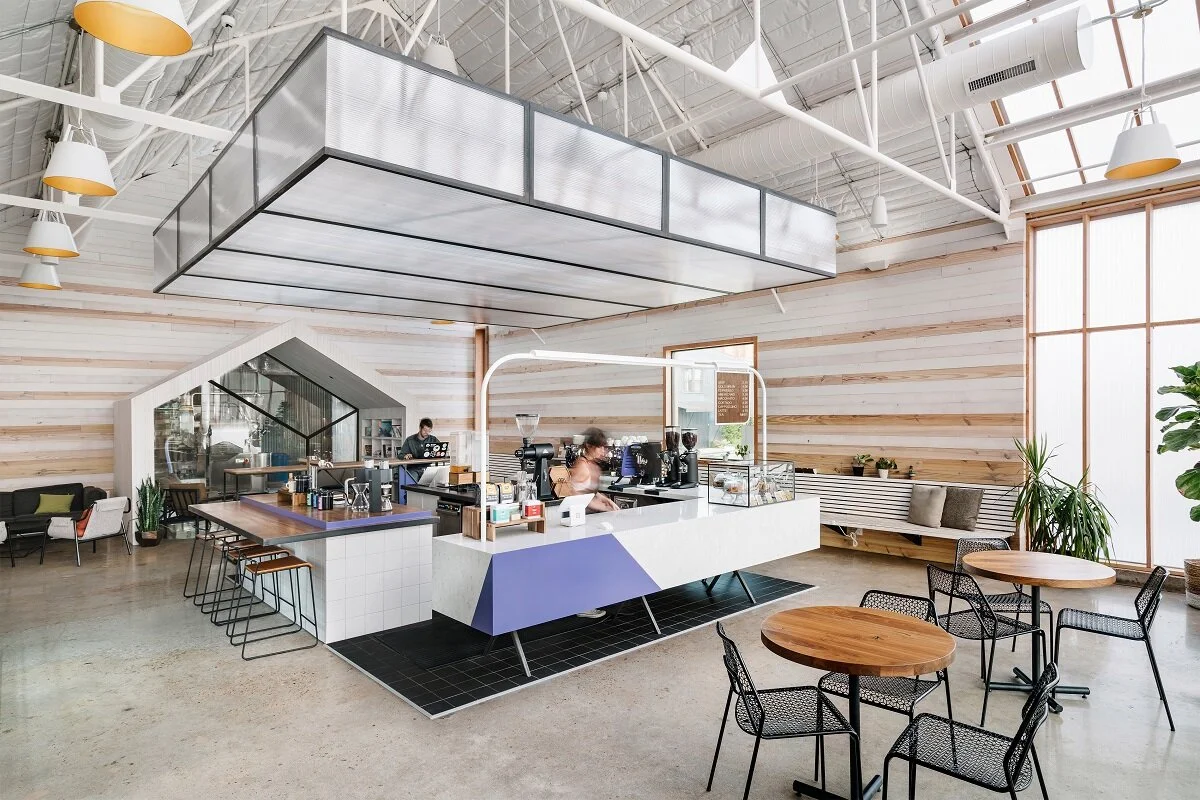 The interior of the Greater Goods’ space, featuring a centrally placed coffee bar allowing guests to interact with baristas from any direction.