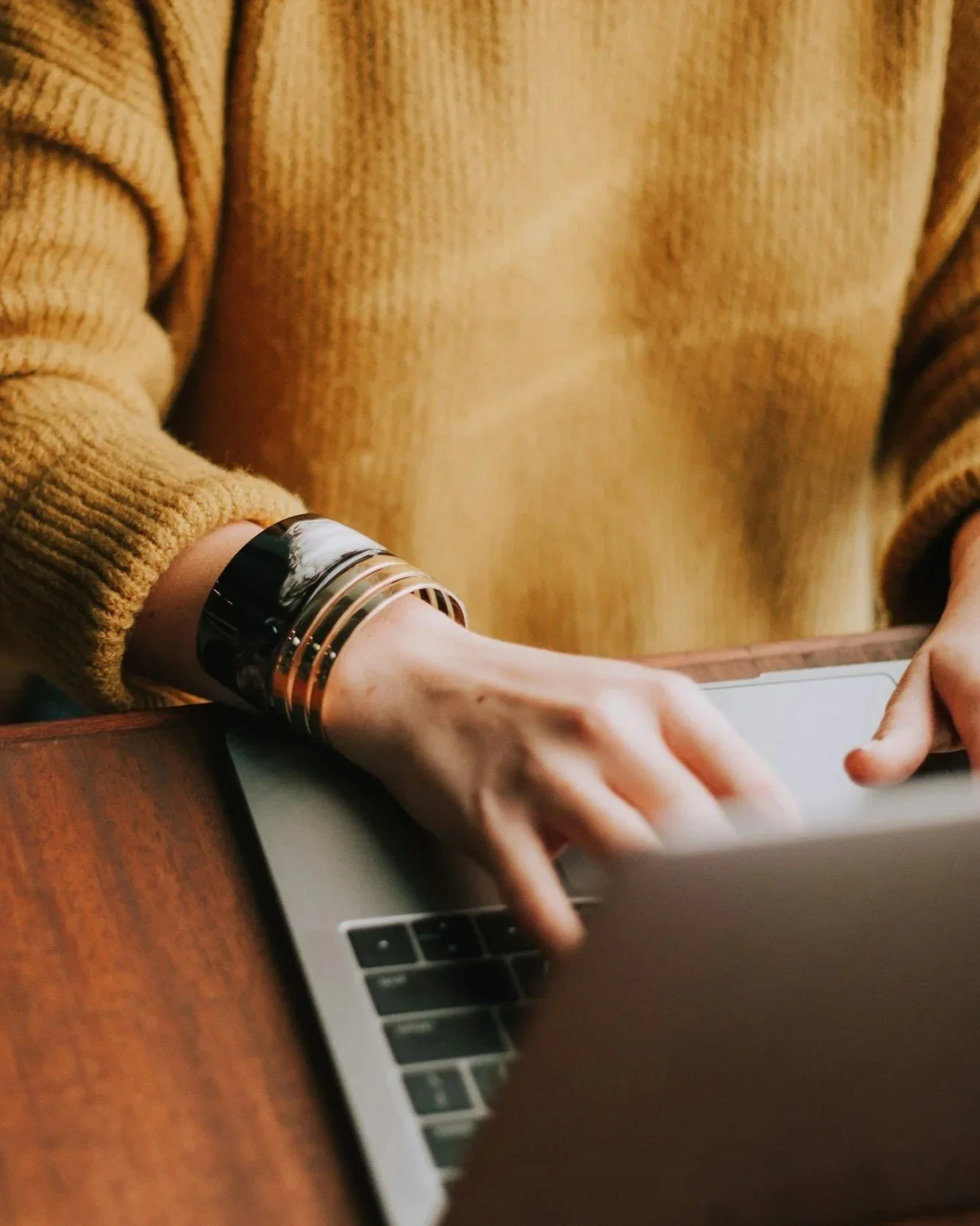 Close up view of a person on a laptop with their hands on the keyboard