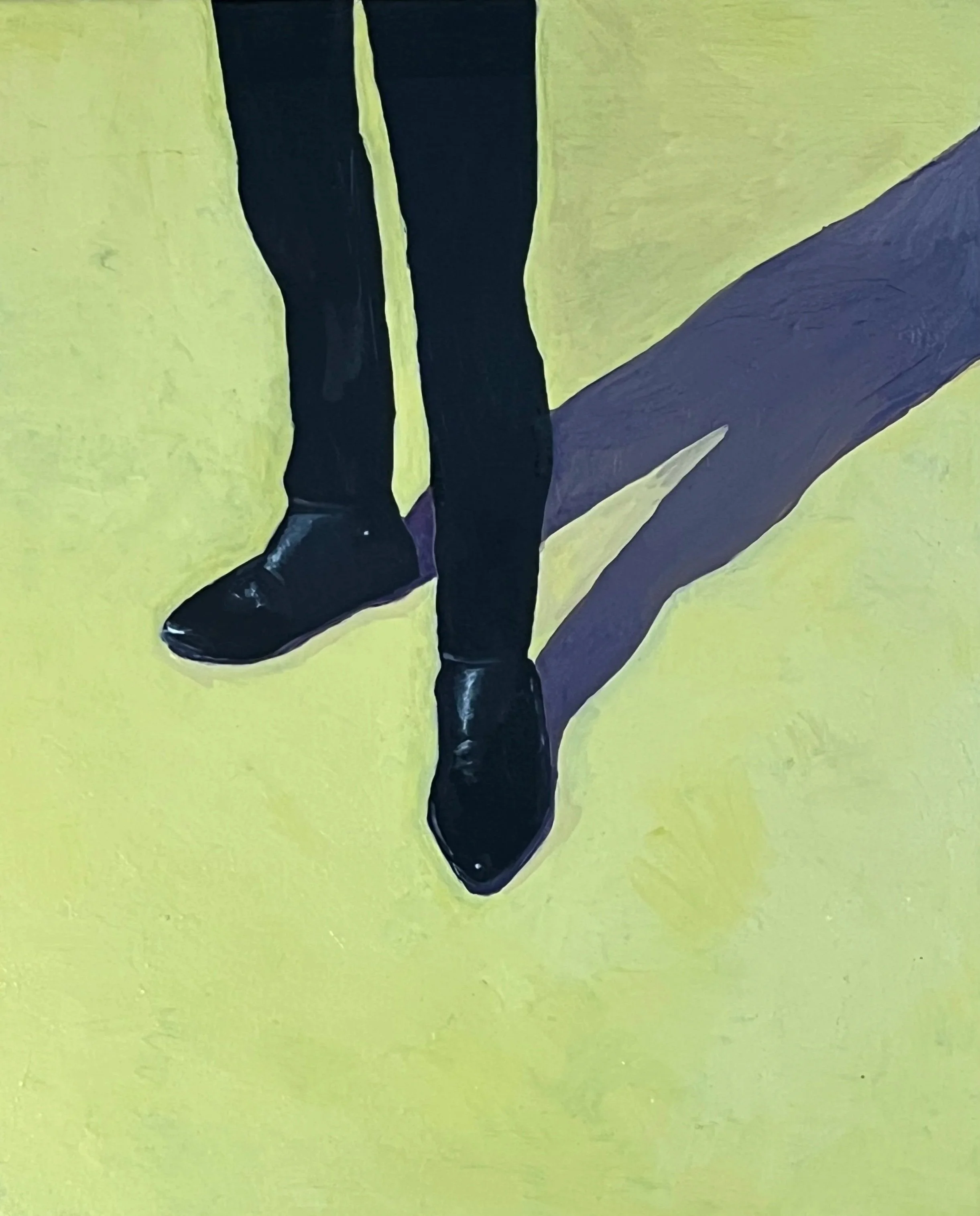 Die Schuhe einer Person, die schwarze Stiefel trägt, auf einem gelben Boden mit schwarzem Strich.