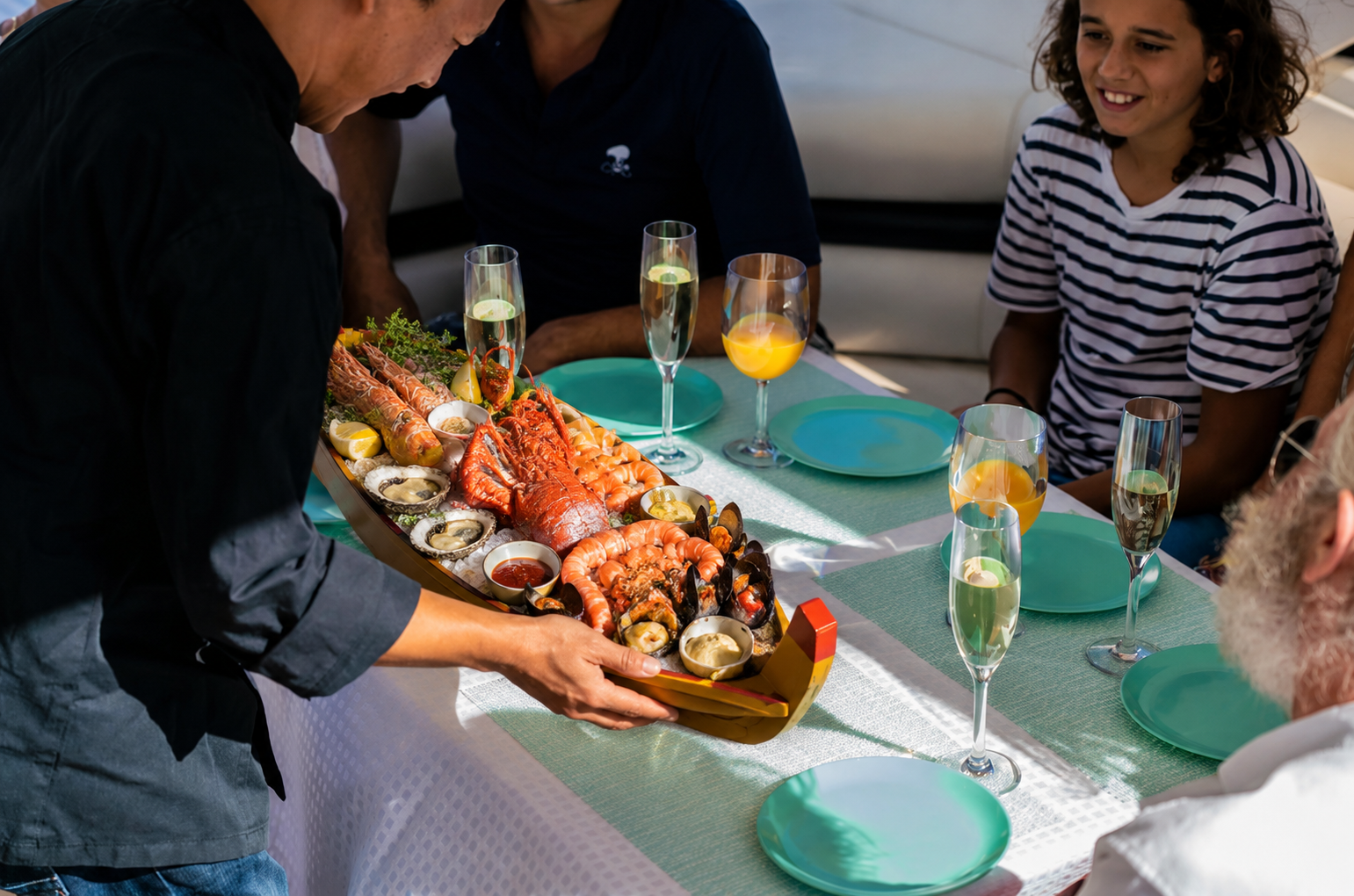 Fresh seafood platter and champagne served at the table on a fully catered luxury boat charter.