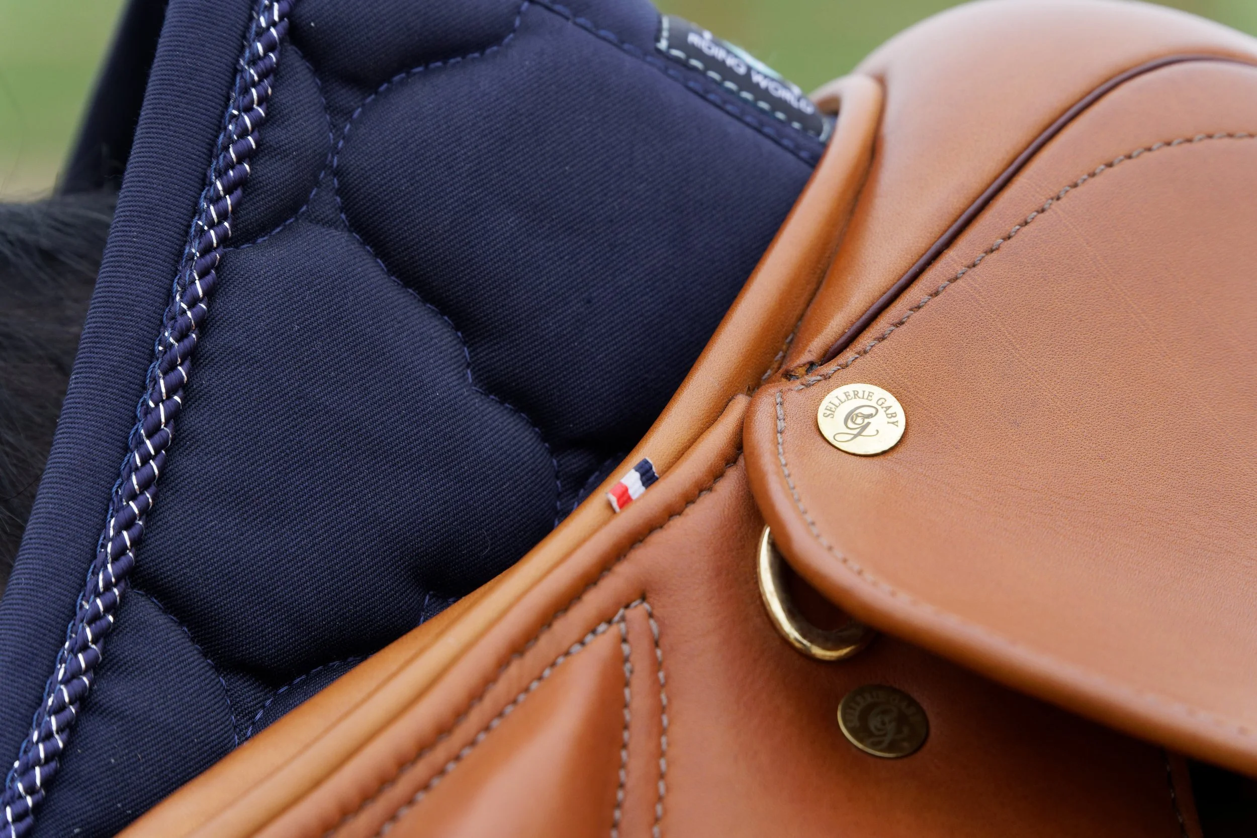 Gros plan de deux sacs à main, l'un en cuir marron et l'autre en tissu navy, avec des détails en or et un badge or.