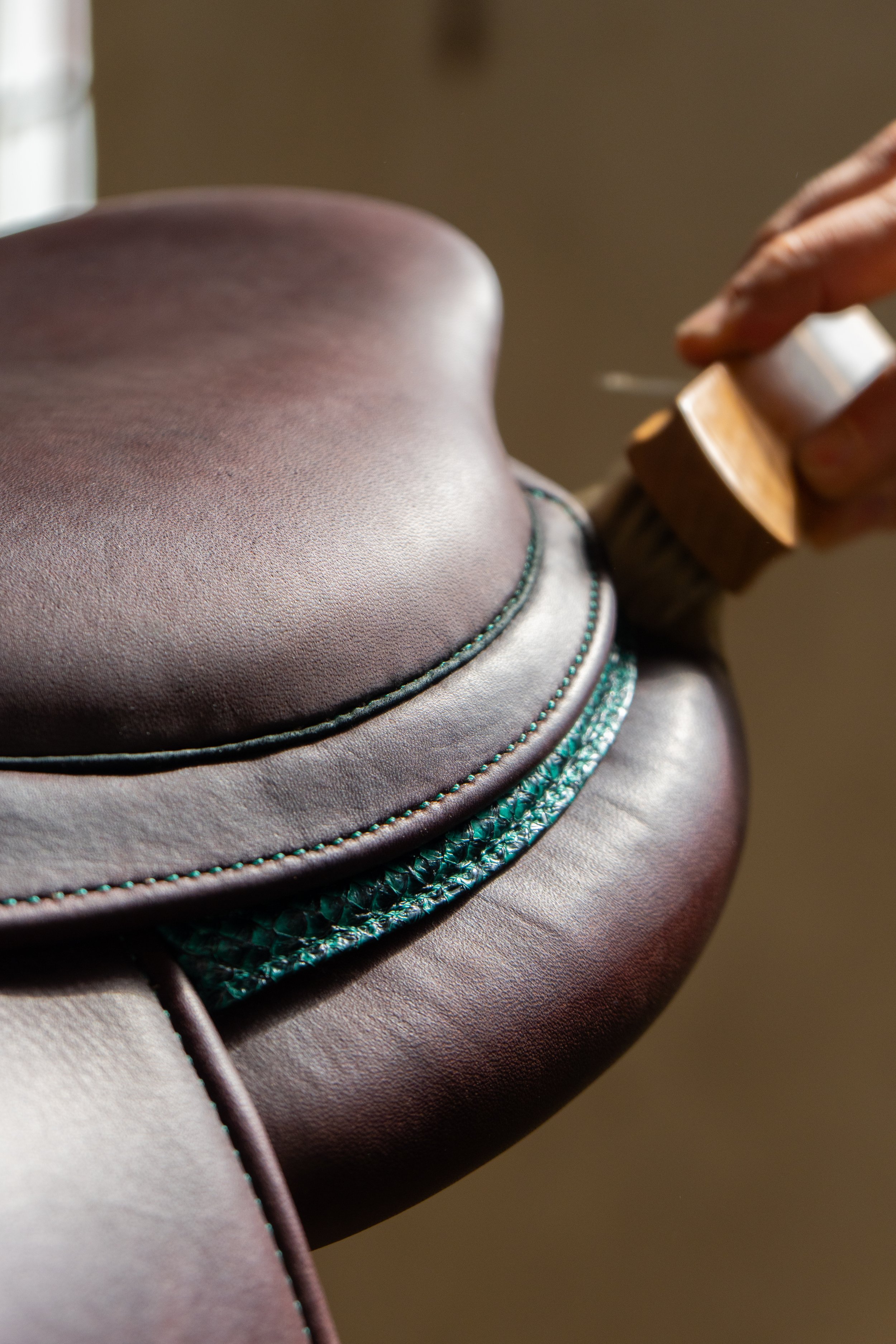 Générique de près d'une selle de cheval en cuir marron avec des détails de couture turquoise.
