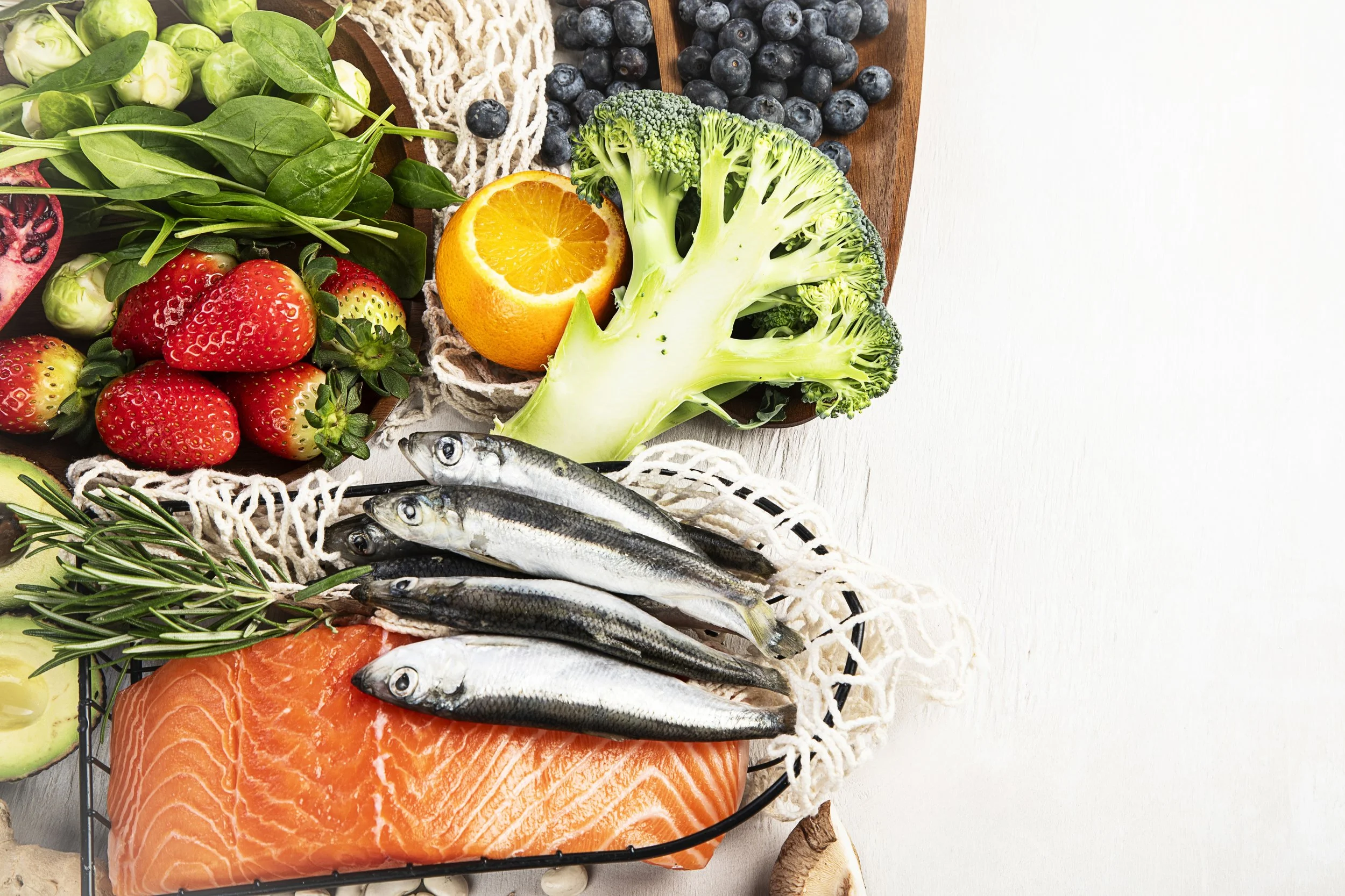 Fresh vegetables, berries, fish, and salmon on a white background.