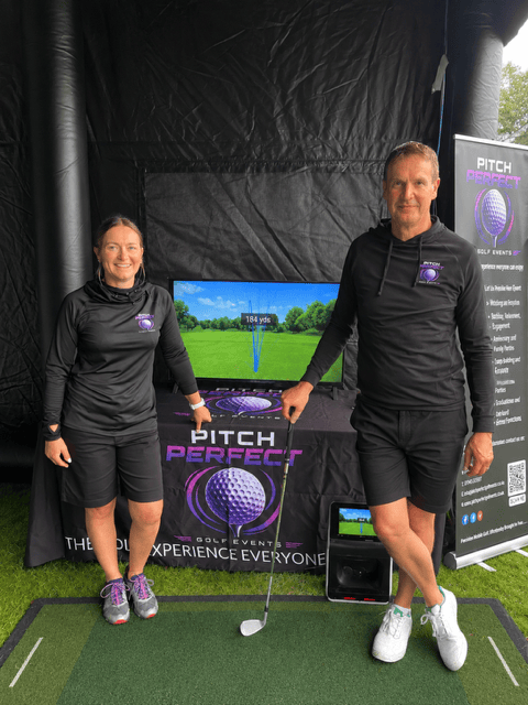 Pitch Perfect Golf Events business owners Mick and Mandie Percival dressed in branded uniform in front of a TV screen showing the flight of a golf ball