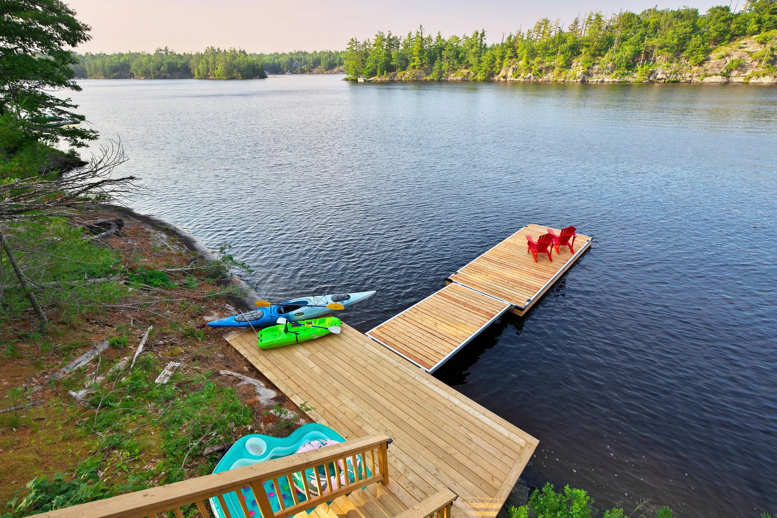 Waterfront Muskoka cottage dock and calm lake at sunset on Muldrew Lake in Gravenhurst