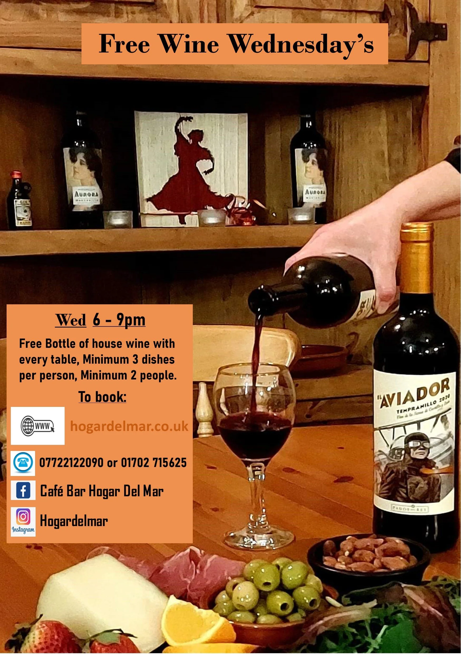 A poster advertising free wine at the café on Wednesday from 6 to 9 pm, with a glass of red wine, a bottle of wine, and various foods including cheese, strawberries, grapes, nuts, and lemon slices on a table in the foreground. The background shows a wooden shelf with bottles of alcohol and a silhouette of a dancer.