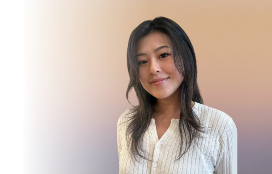 A young woman with long dark hair wearing a white textured shirt, smiling at the camera against a gradient beige background.