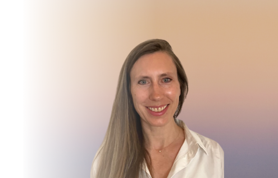 A woman with long, straight, light brown hair, smiling and wearing a white shirt, standing against a neutral gradient background.