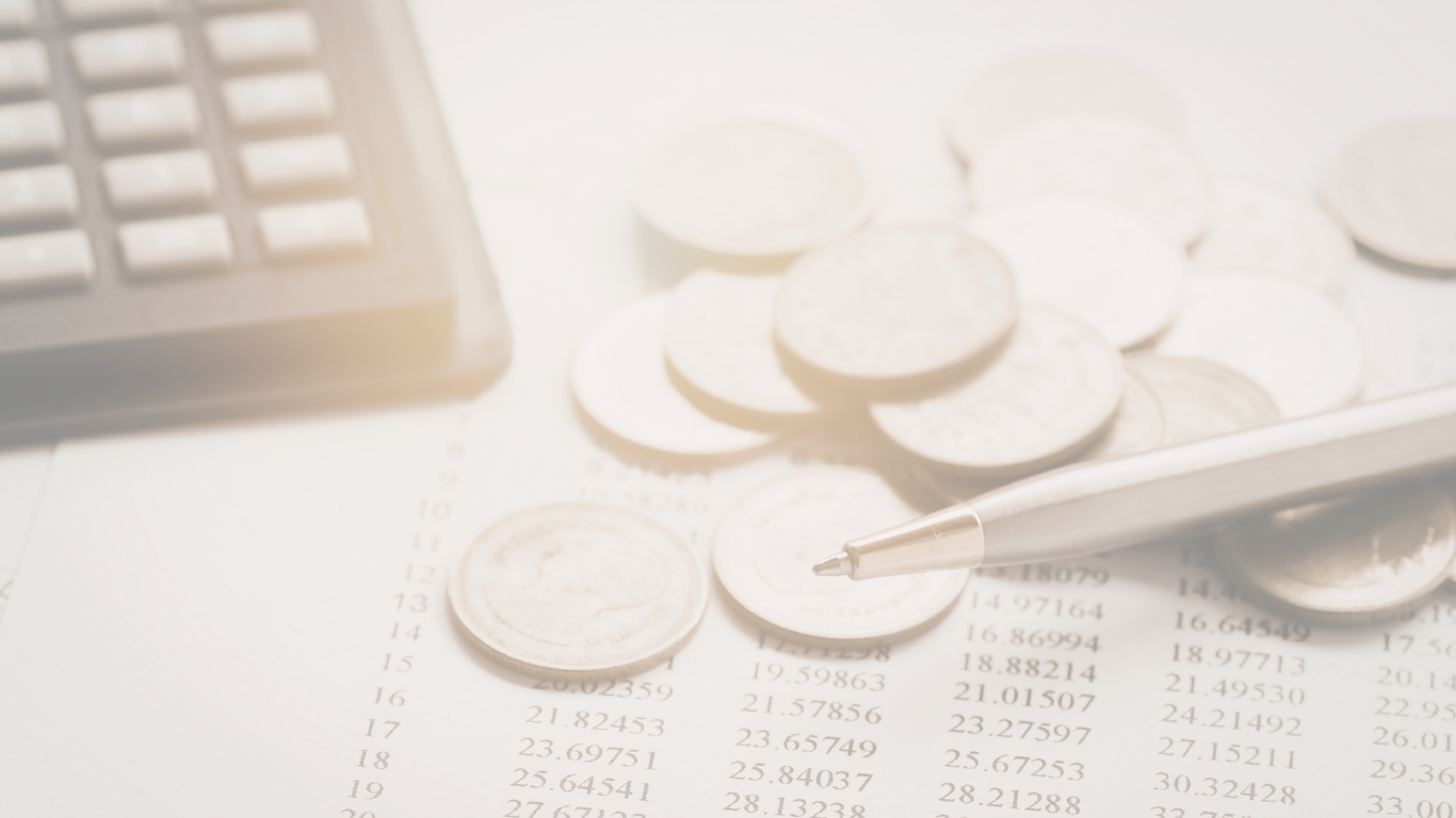 Coins scattered on a paper with financial data, a calculator, and a pen.