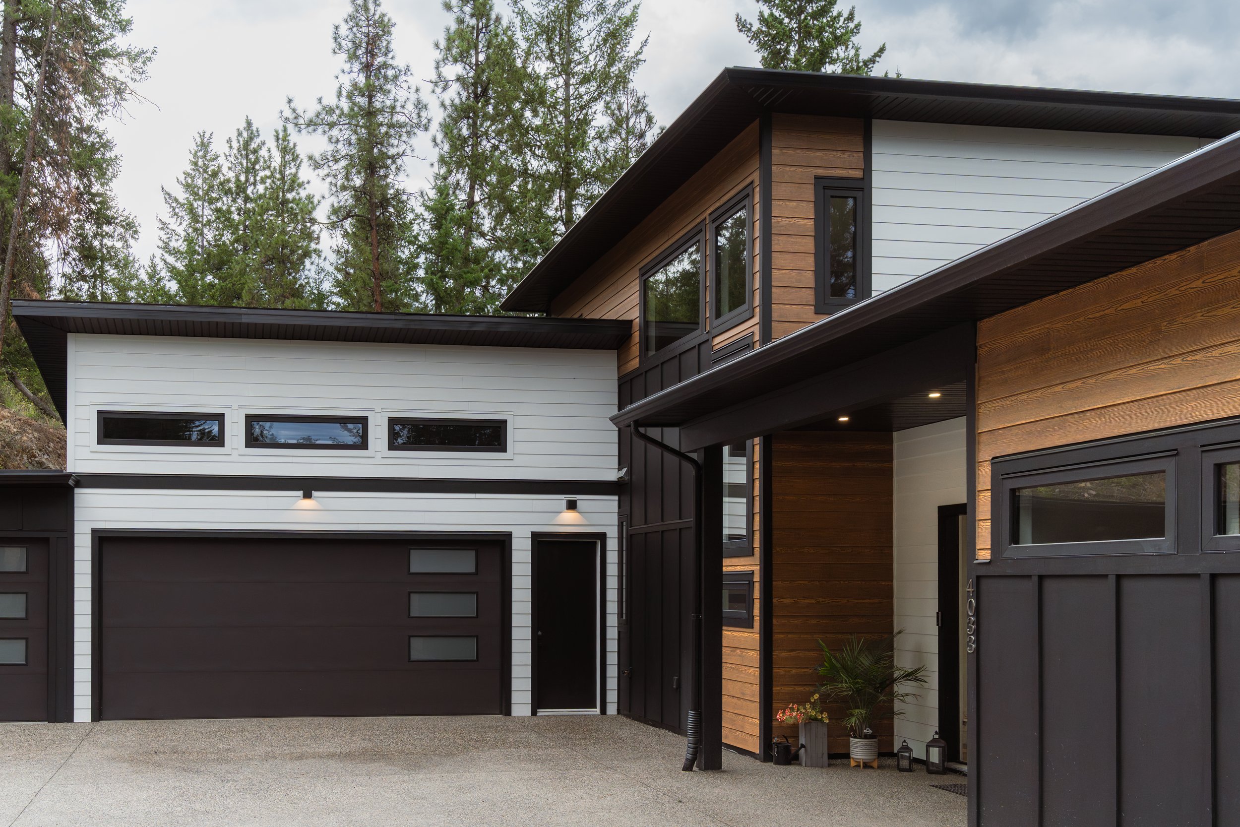 Modern houses with garage doors in an area surrounded by trees
