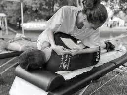 Une personne allongée sur une table de soins, recevant un massage ou une manipulation thérapeutique, avec une autre personne effectuant le traitement.