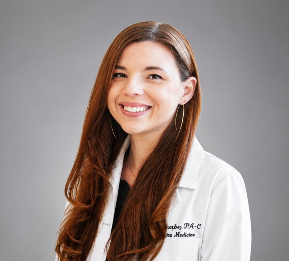 A photo of Sylvia Brandenburg, with long auburn hair and hoop earrings smiling at the camera, wearing a white lab coat.
