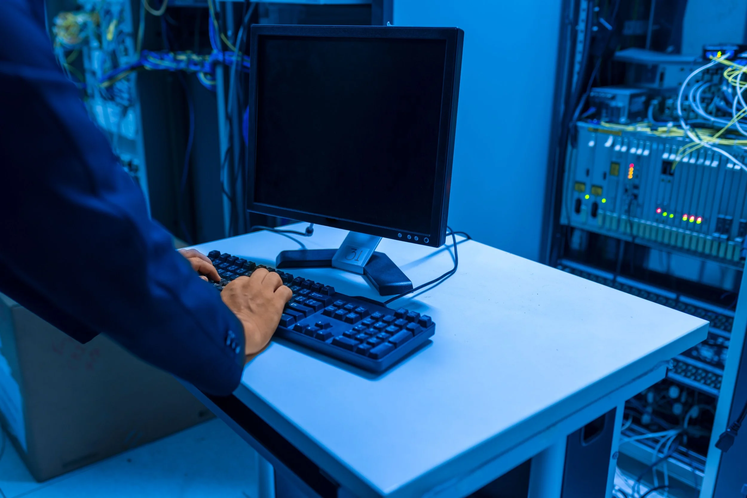 Network administrator configuring enterprise voice and data server racks managed by A/Coe Communications.