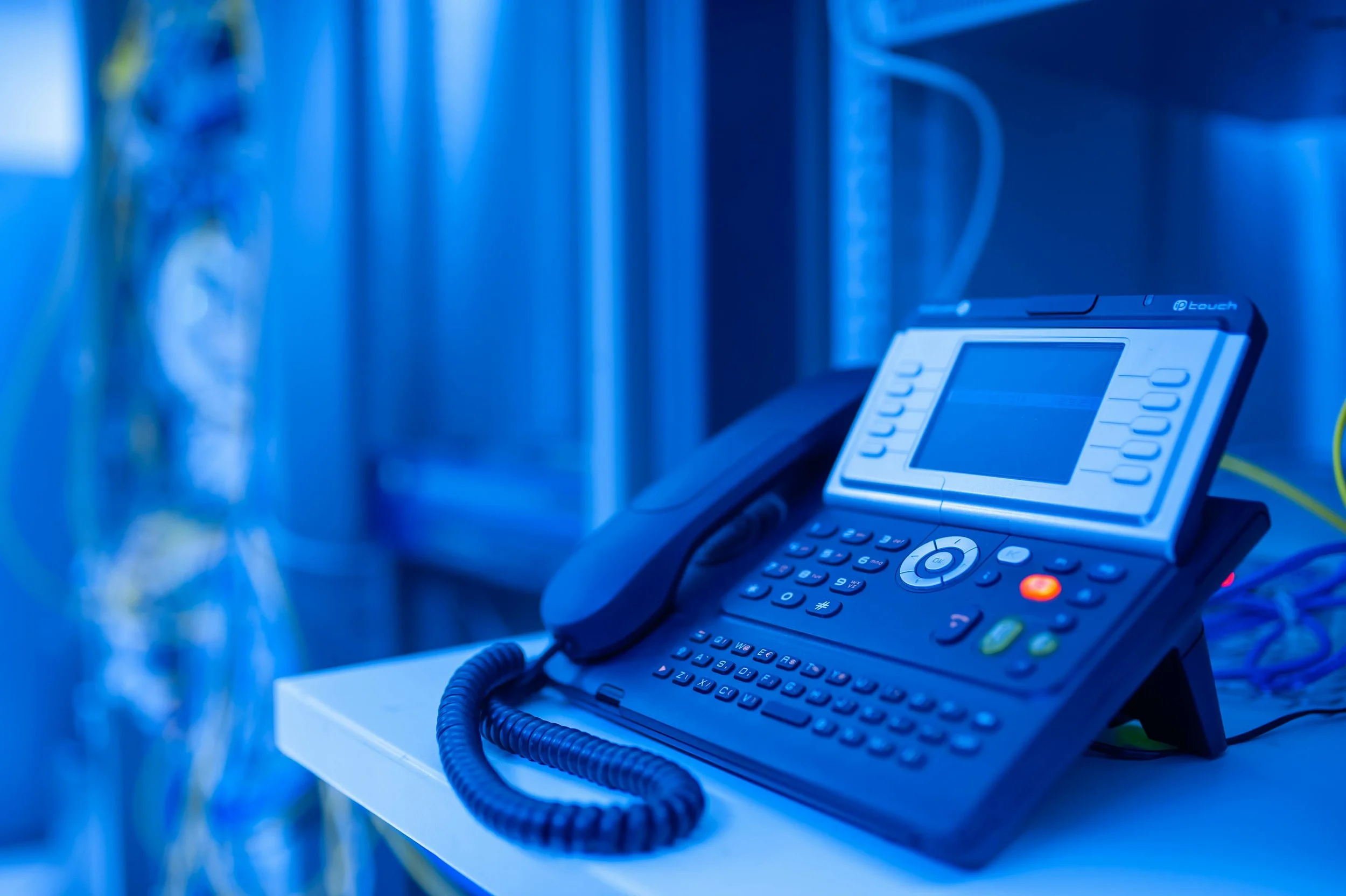 Modern IP desk phone connected to an A/Coe Communications turn-key VoIP telecommunications network.