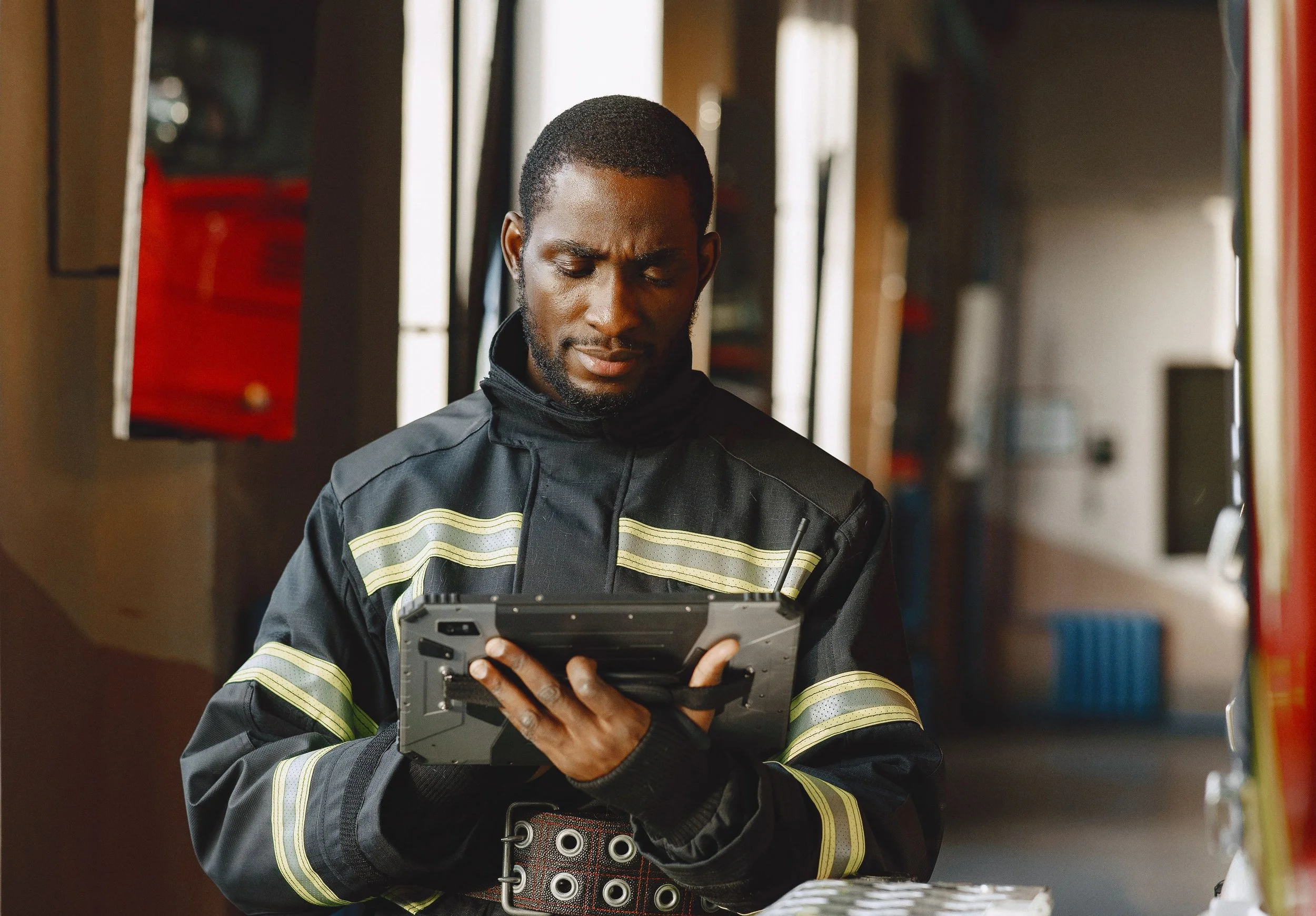 First responder using a tablet, representing A/Coe Communications code-compliant ERRCS public safety radio coverage.